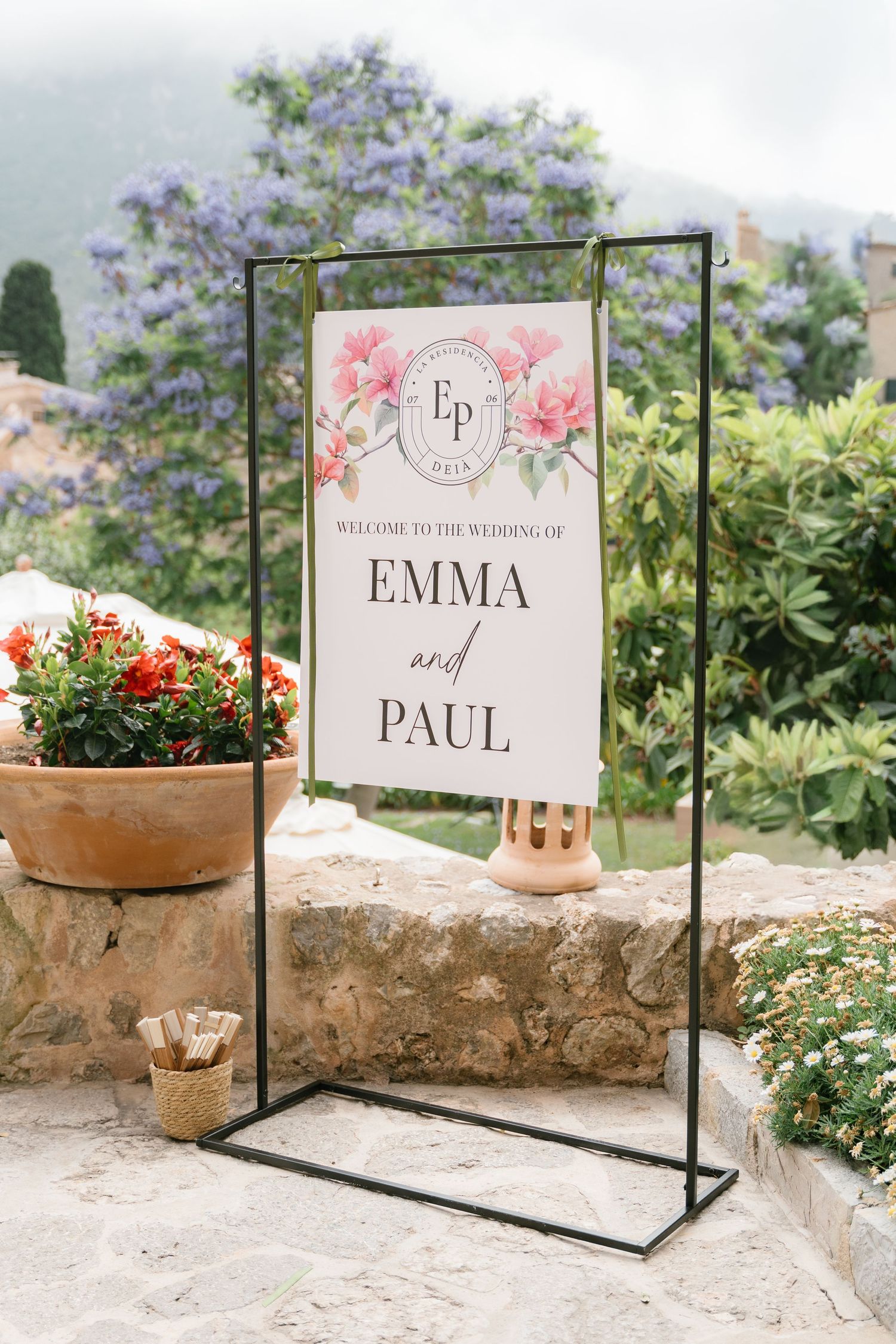 Wedding welcome signs for Emma and Paul displayed on metal stands with floral decorations.