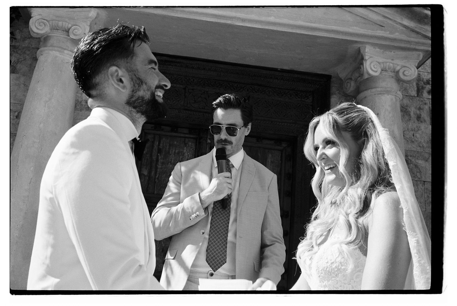 Wedding couple laughing together during an intimate moment outdoors.