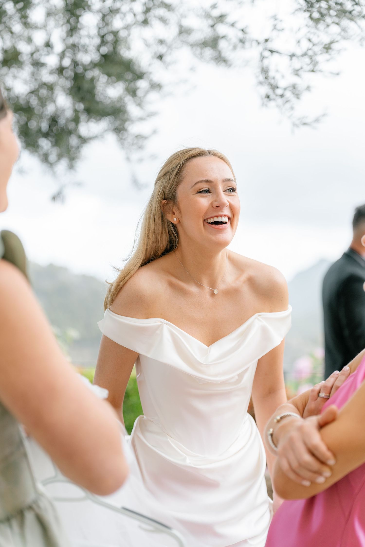 Joyful moments captured during outdoor wedding celebration with natural scenery.