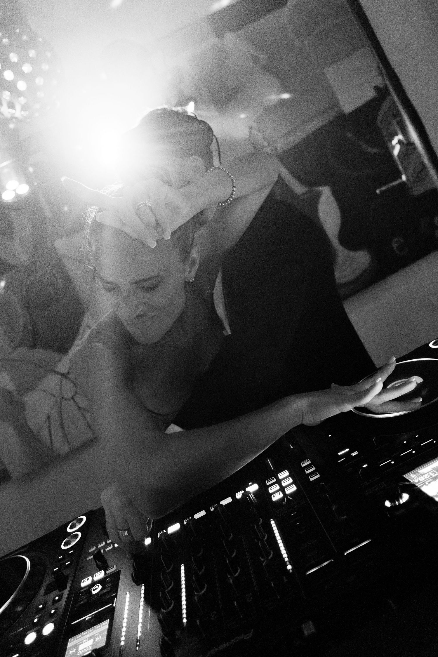 DJ equipment setup at wedding reception with dramatic lighting effects in black and white.