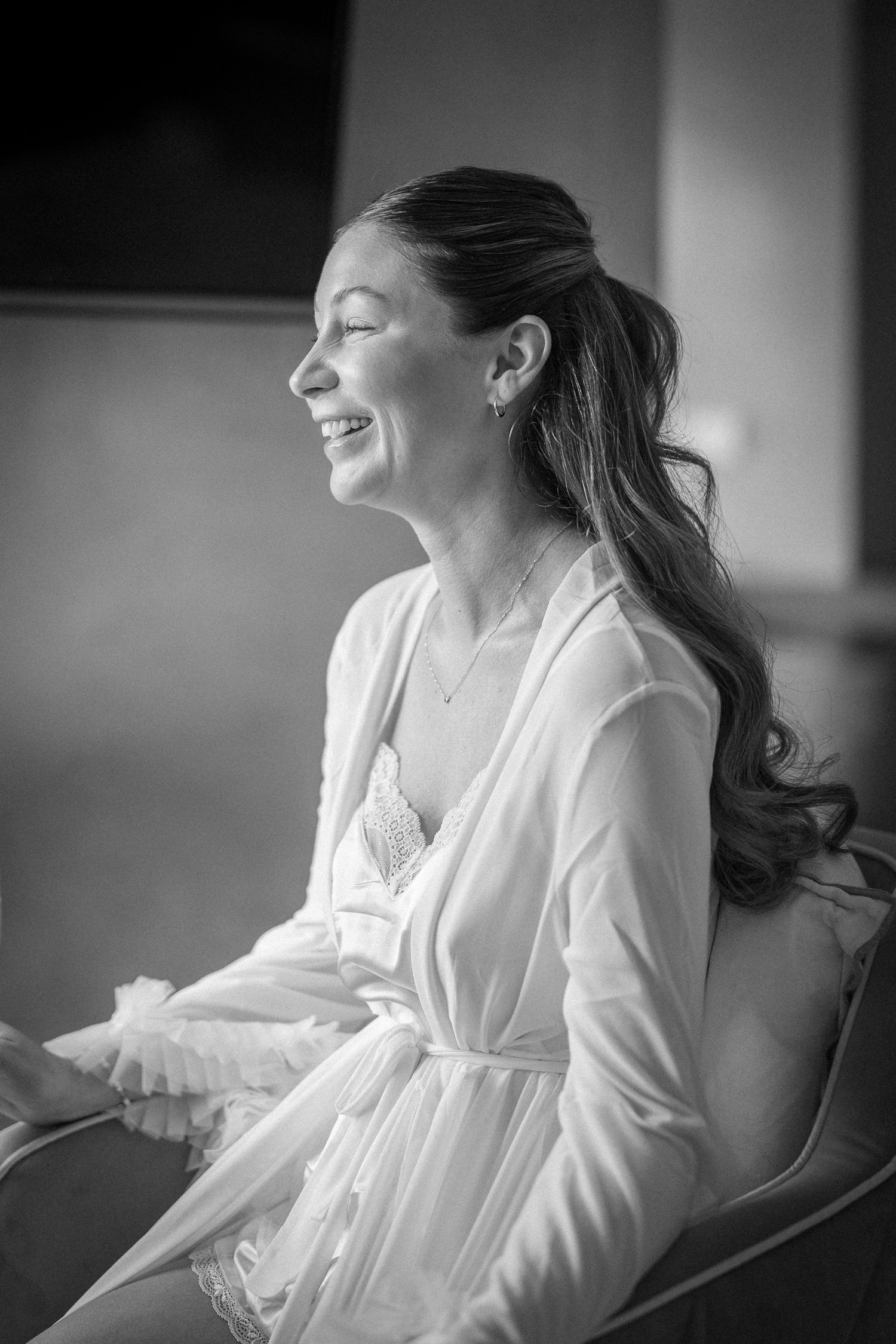 Black and white candid moments during wedding preparations in soft lighting.
