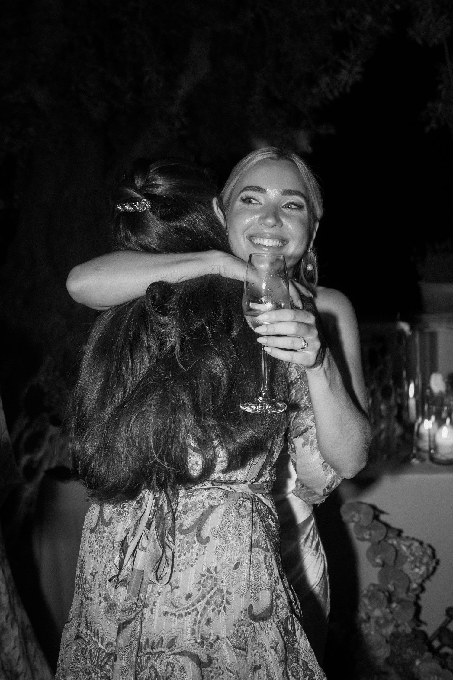 Wedding guests dancing and enjoying drinks at a dimly lit reception.