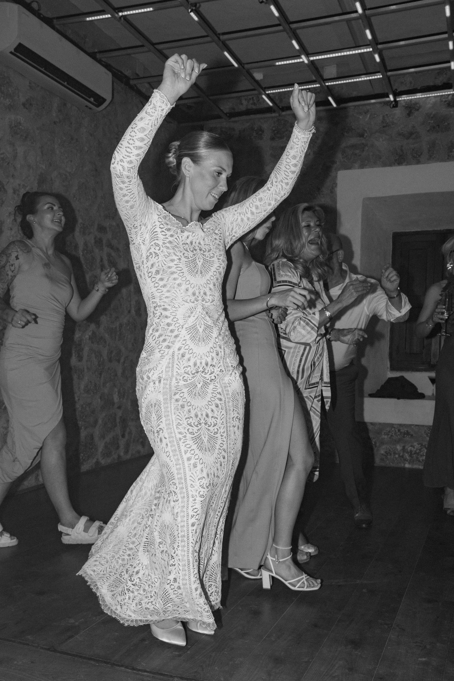Dancers in elegant attire moving on a dimly lit indoor dance floor.