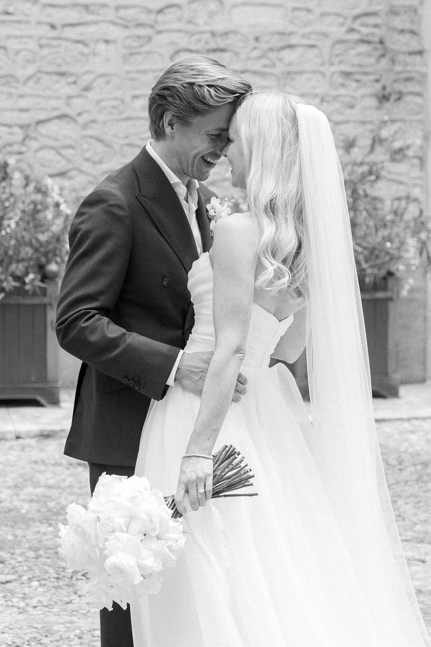Romantic wedding couple shares intimate moments in a garden setting.