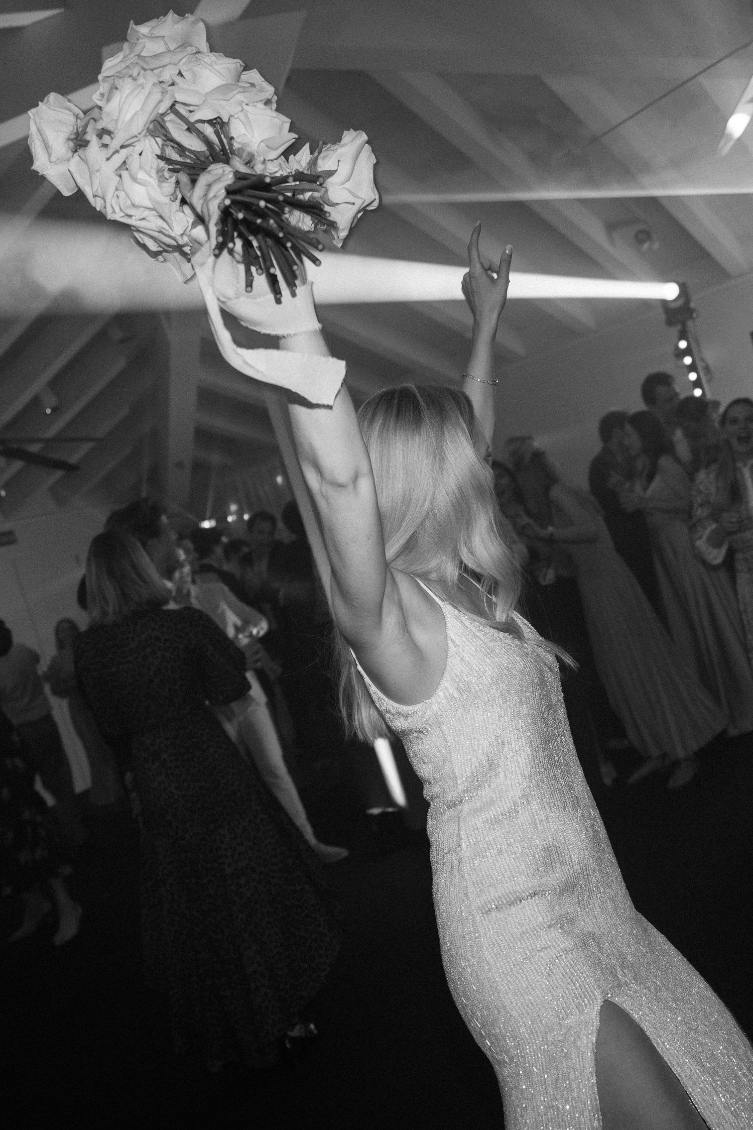 Bride in sparkling dress twirling on the dance floor during wedding reception.