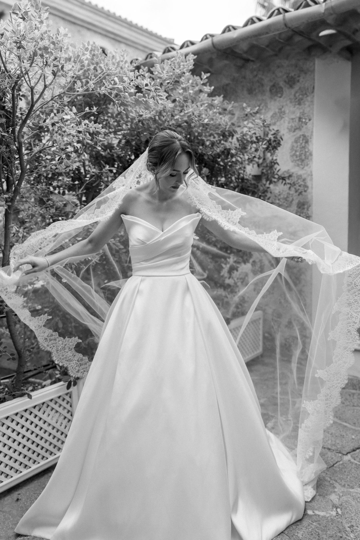 Artistic shots of a flowing white wedding gown with delicate veil details.