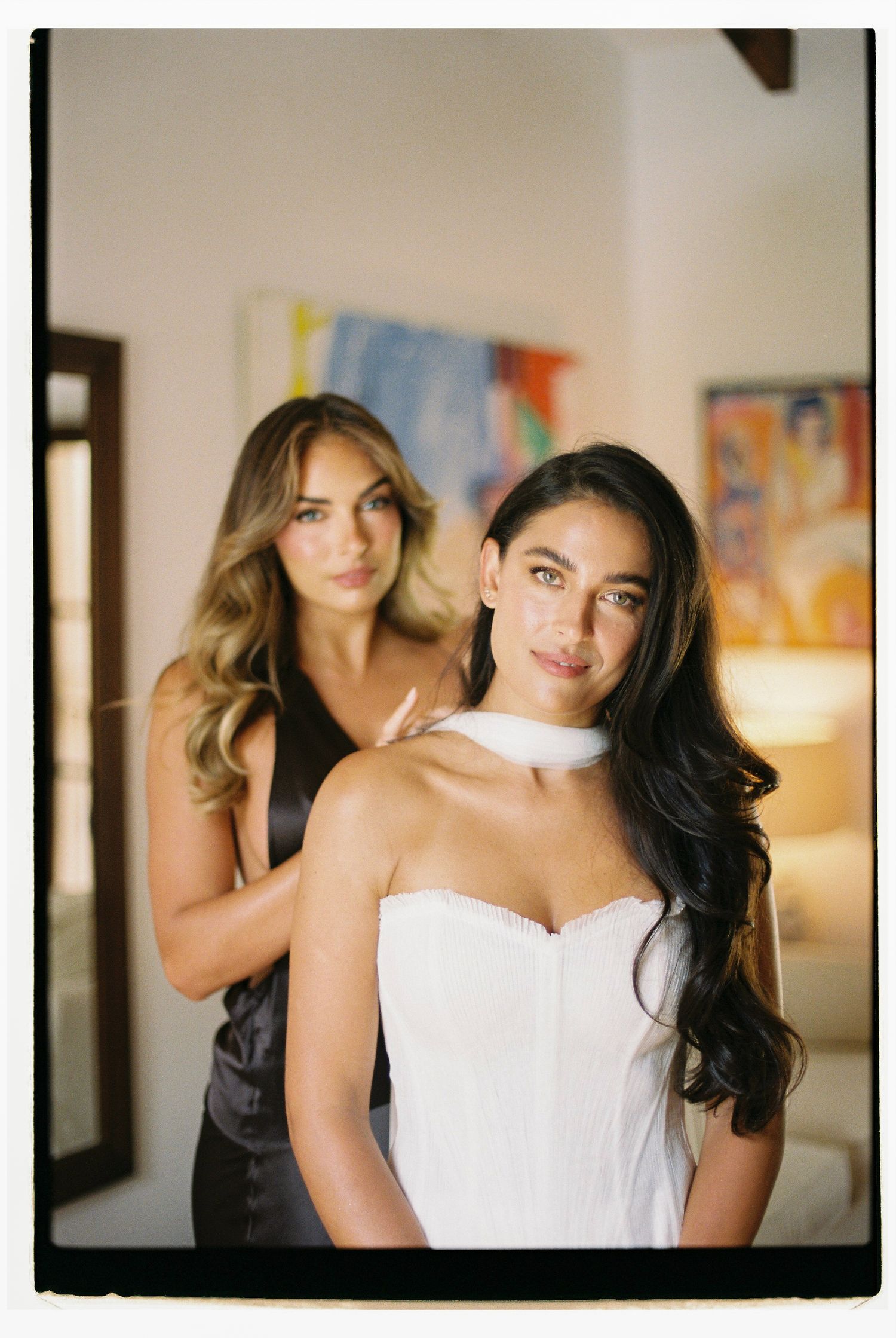 Wedding party members in black and white dresses posing together.