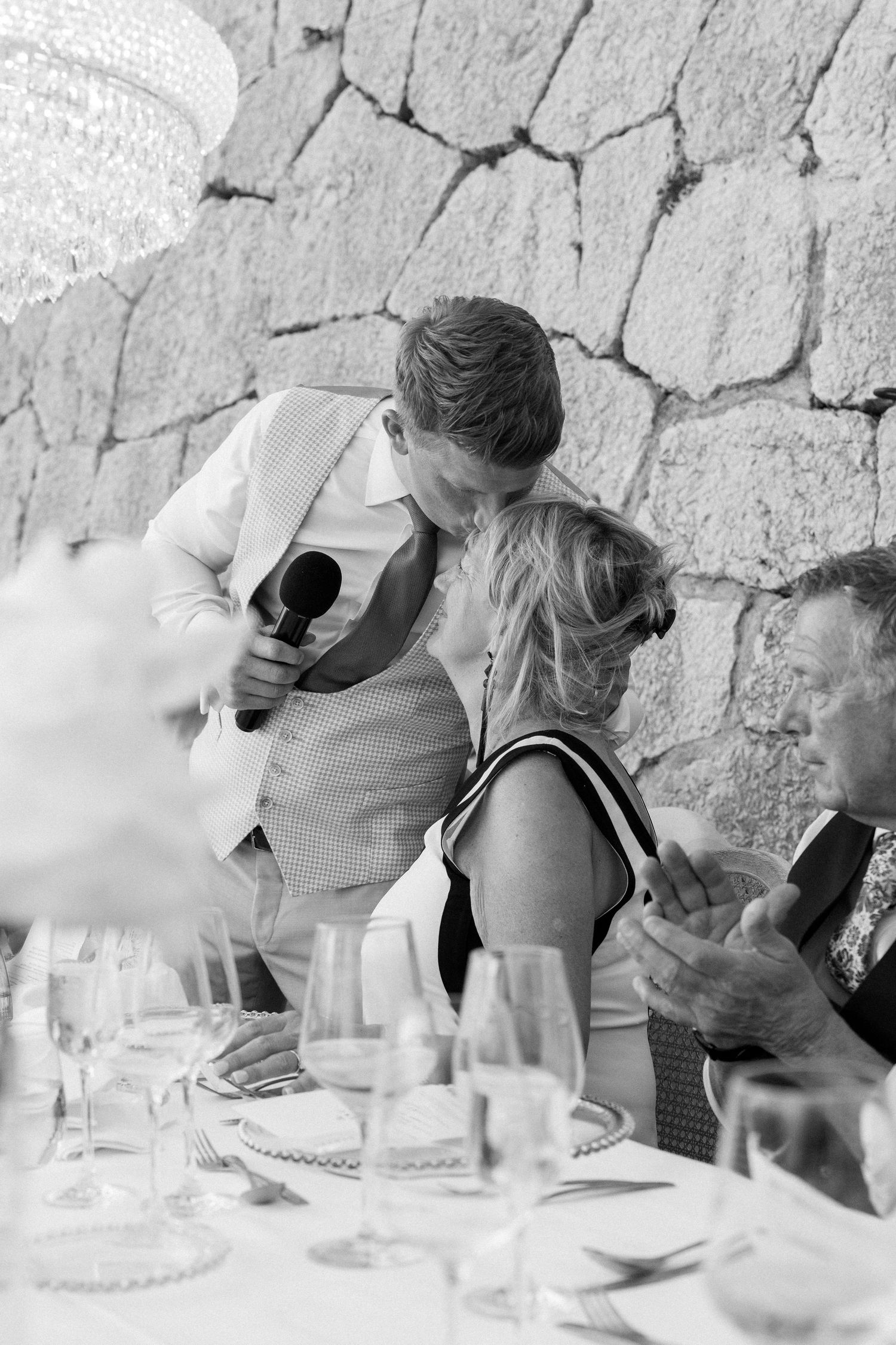 A group of people leaning over a table during what appears to be a wine tasting event.