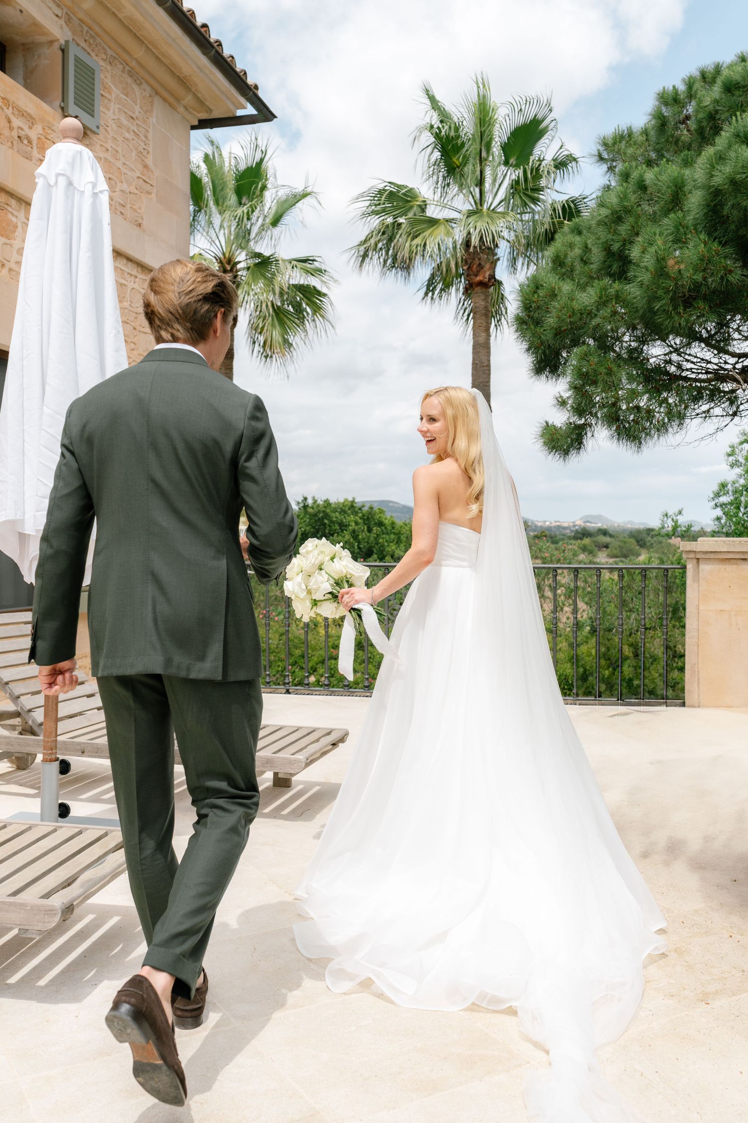 Wedding couple walking together on a Mediterranean style terrace with scenic views.