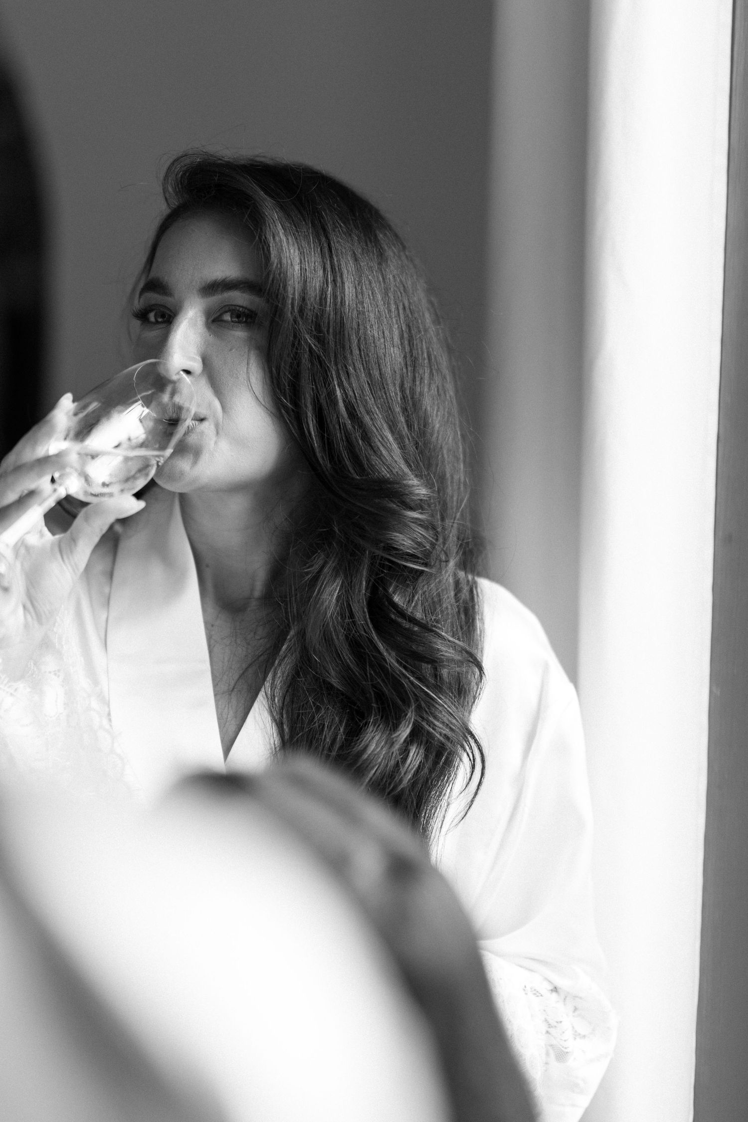 Black and white portrait series showing intimate getting ready moments in soft natural light.