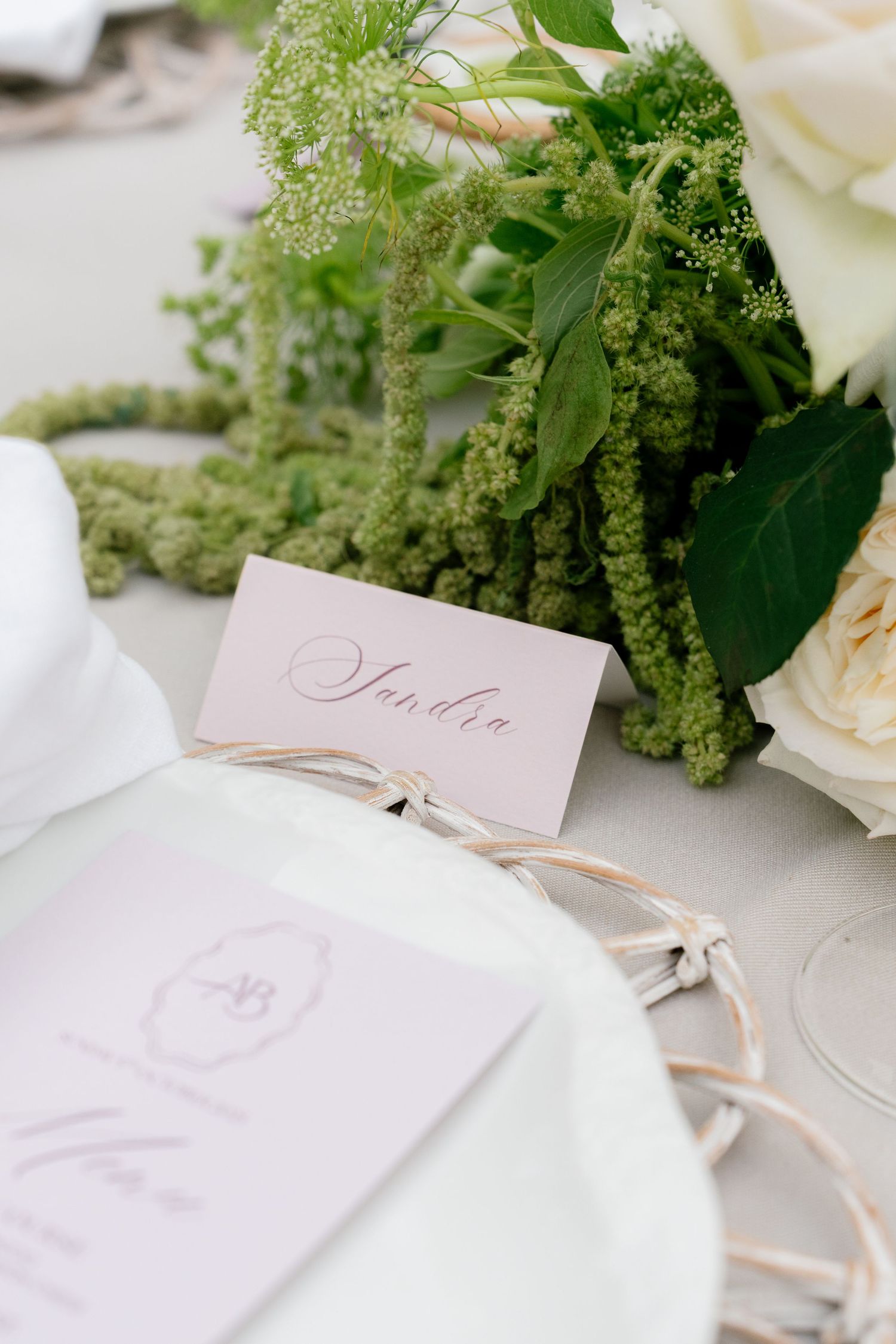 Elegant place cards and floral arrangements adorn wedding reception table settings.