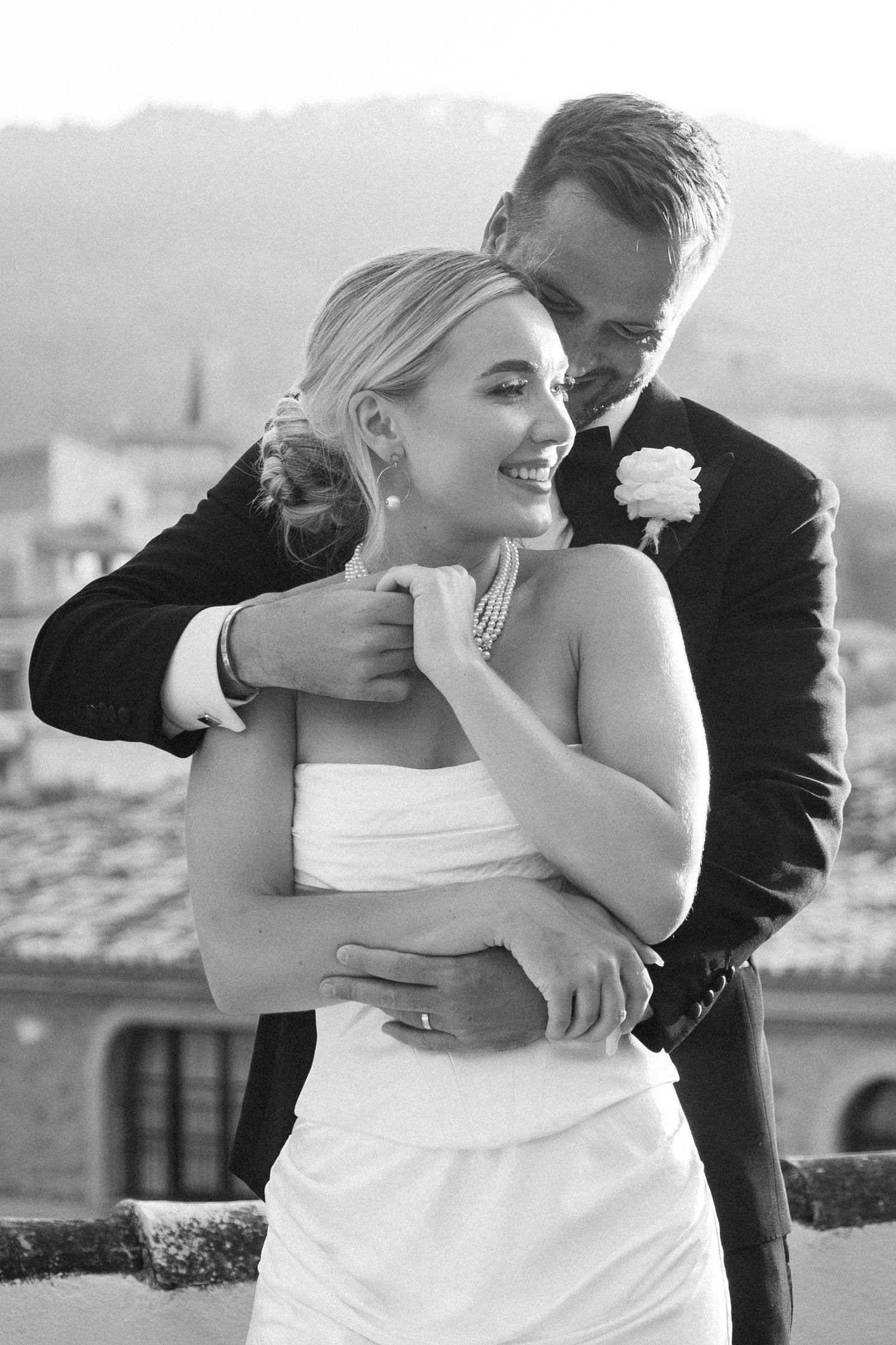 Black and white intimate wedding portraits showing tender embraces against a scenic backdrop.