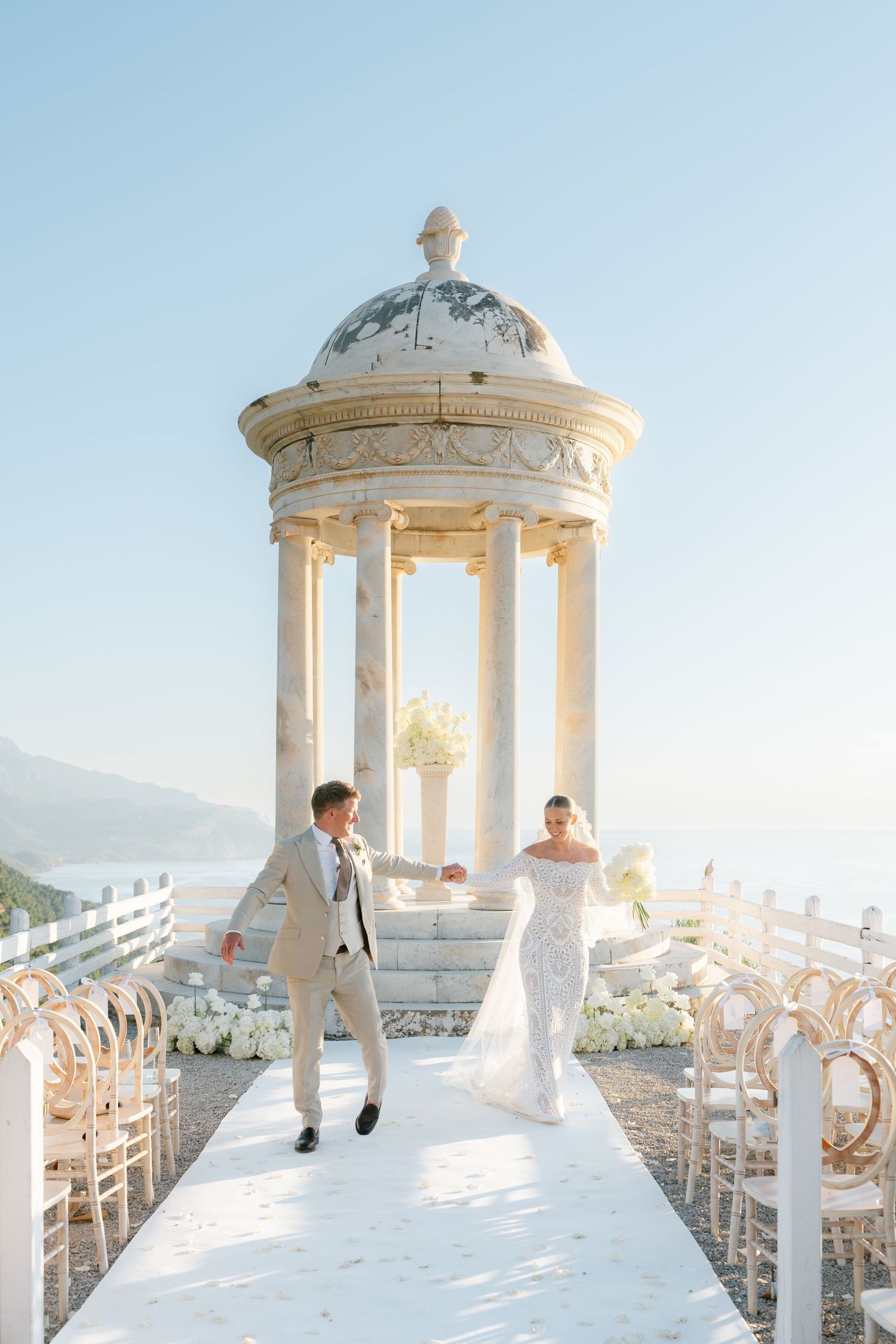 Wedding ceremony moments captured at an elegant white stone gazebo venue.