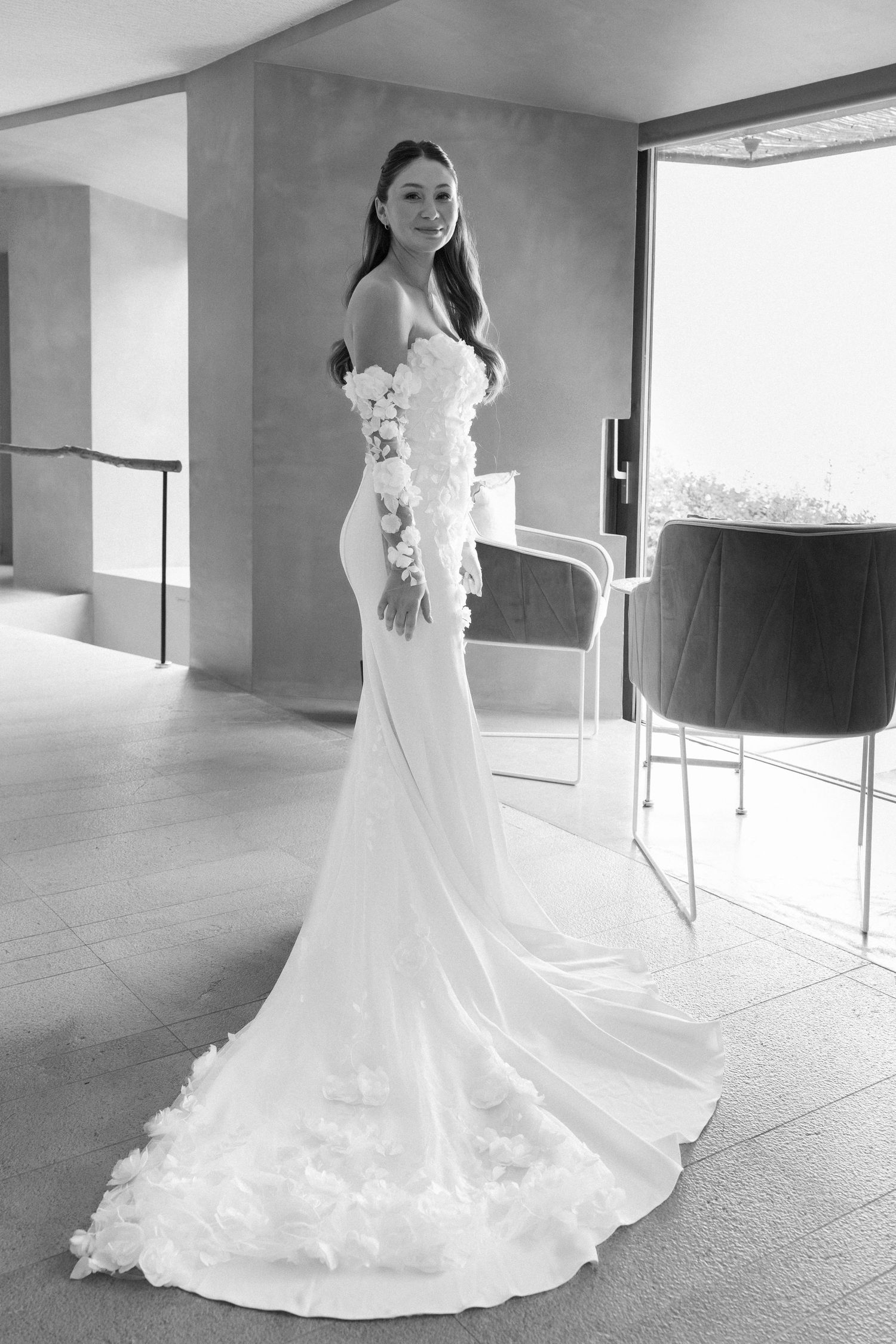 Elegant bridal portraits showing full length view of flowing wedding dress in modern interior.