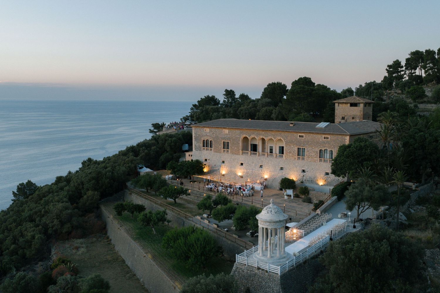Aerial view of luxury villas and buildings along a dramatic coastal cliff.