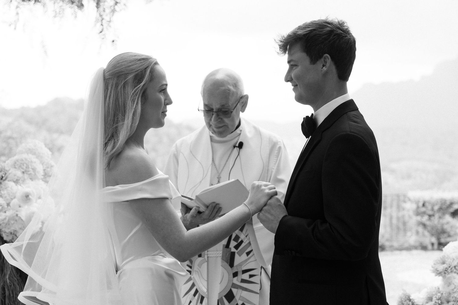 A series of black and white wedding photos showing tender moments between a couple during their ceremony.