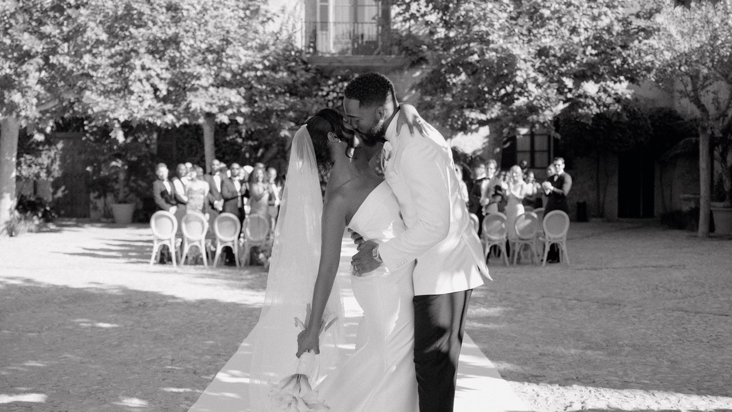 Black and white panoramic view of an outdoor wedding reception setting.