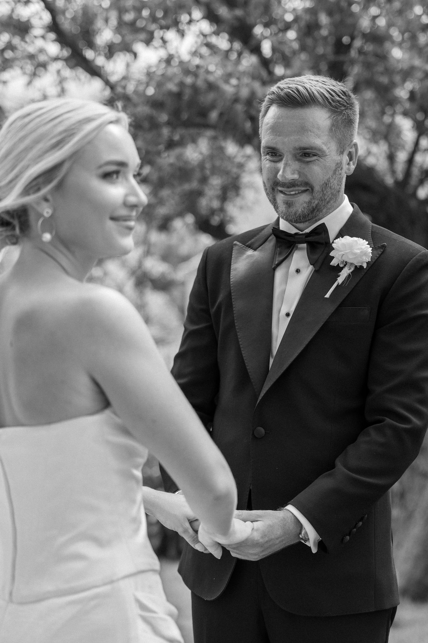 Intimate black and white moment between newlyweds during wedding ceremony.