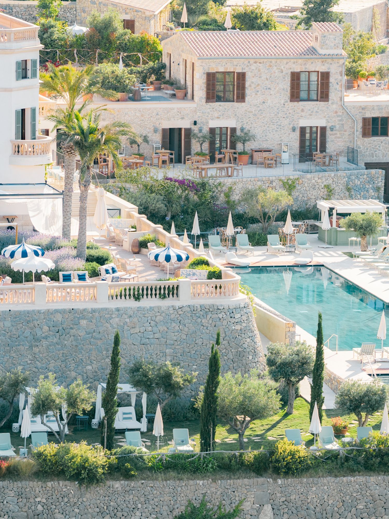 Luxury resort property with stone walls, swimming pool, and Mediterranean landscaping.