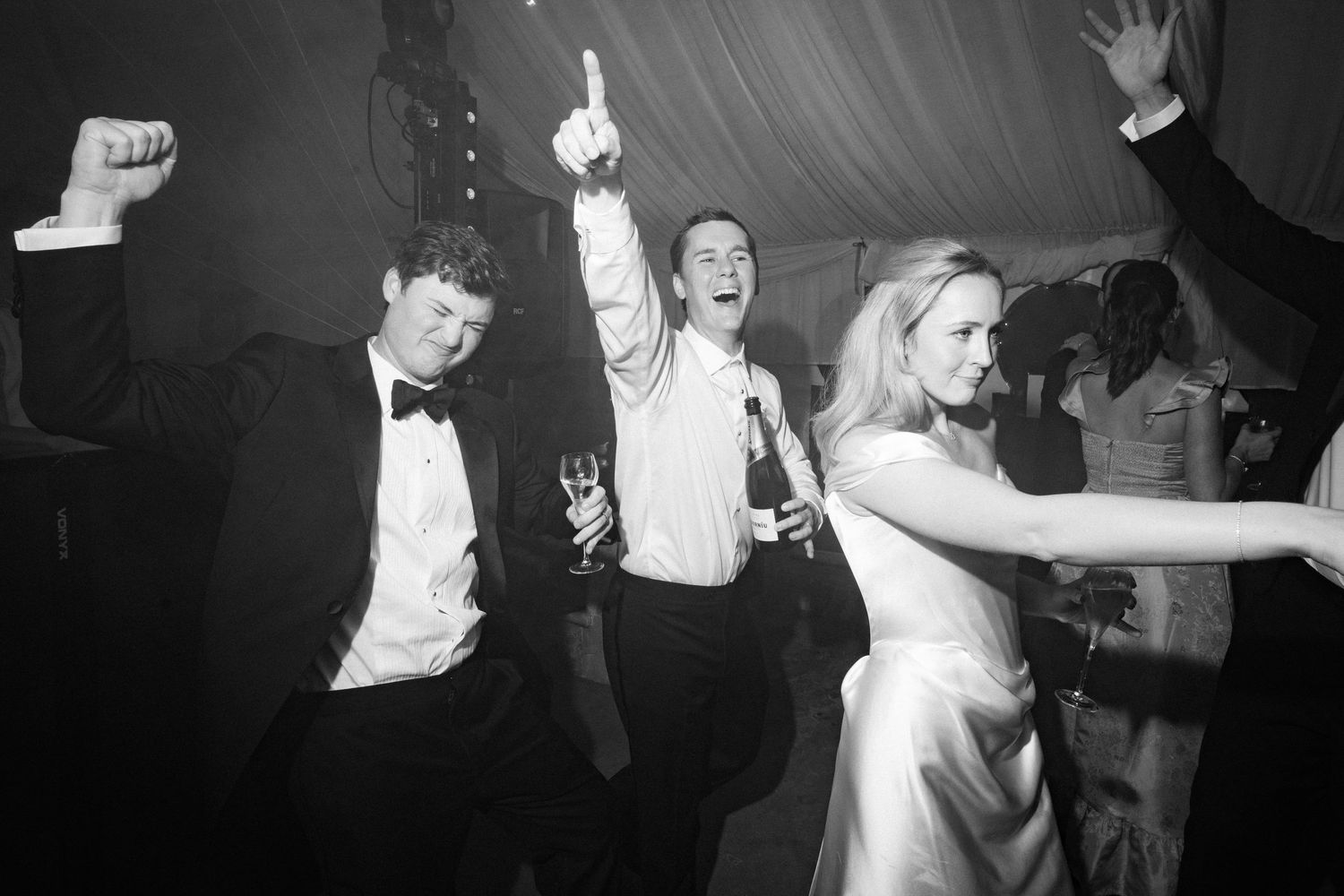 People dancing and celebrating at a lively party with energetic movements on the dance floor.