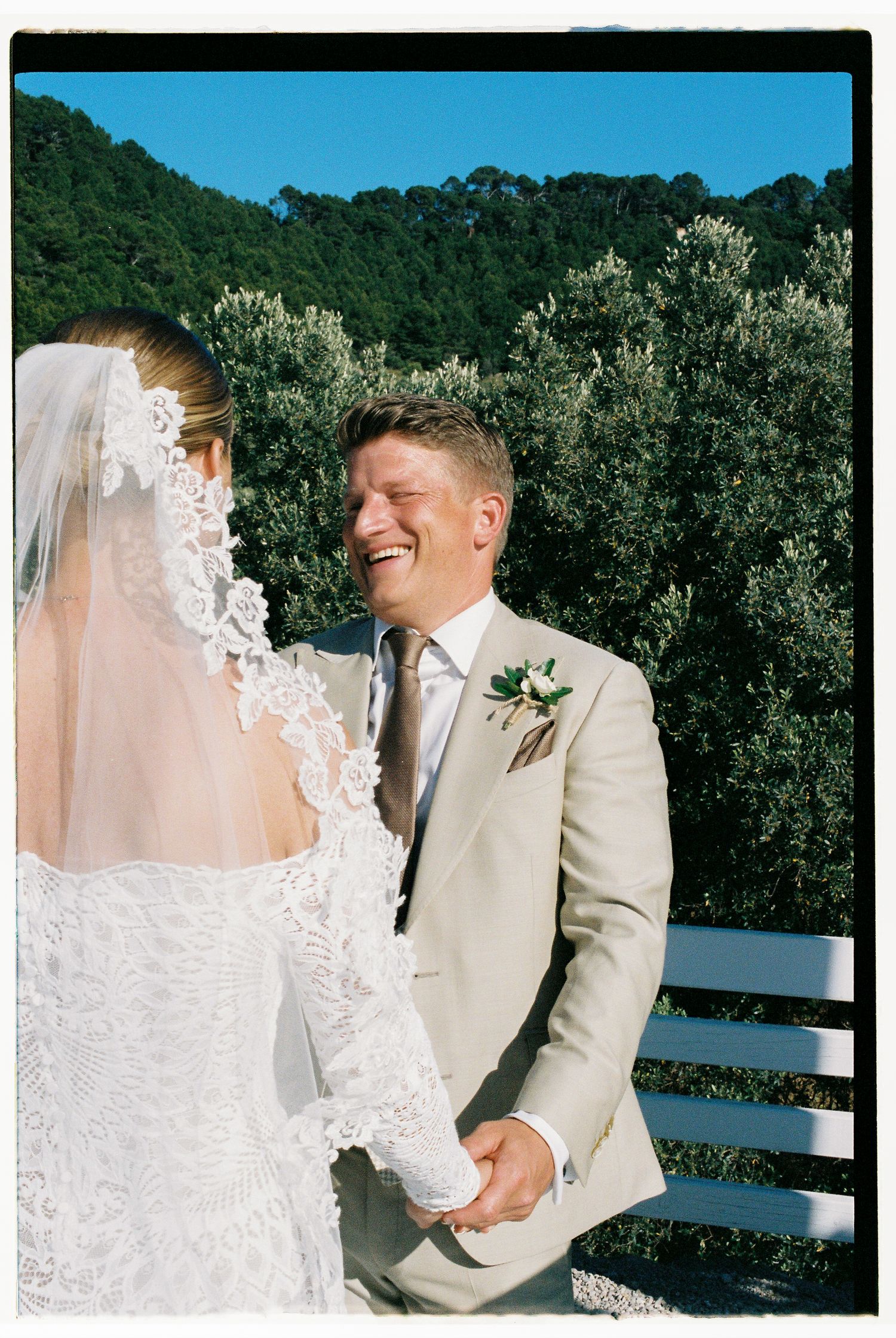 A romantic wedding photoshoot in a natural outdoor setting with mountains in the background.