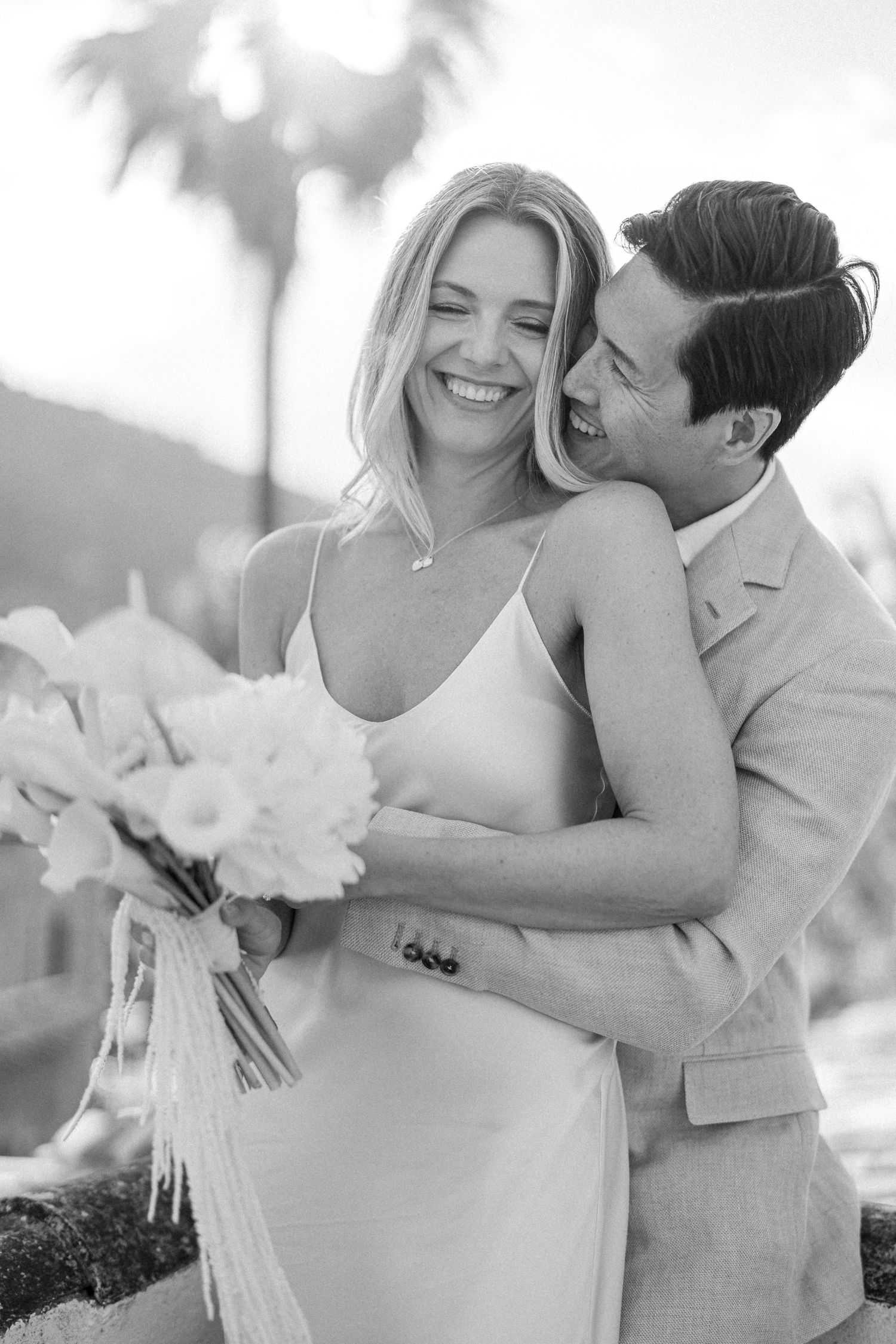 Black and white intimate wedding portrait with couple sharing a joyful moment together.