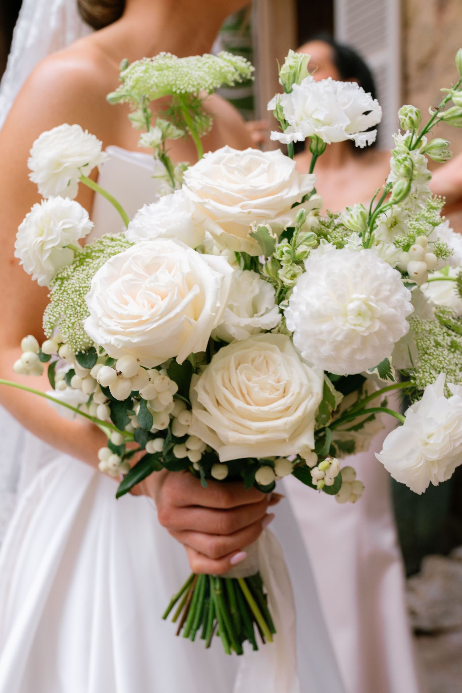 Elegant white rose and greenery wedding bouquets in a row.