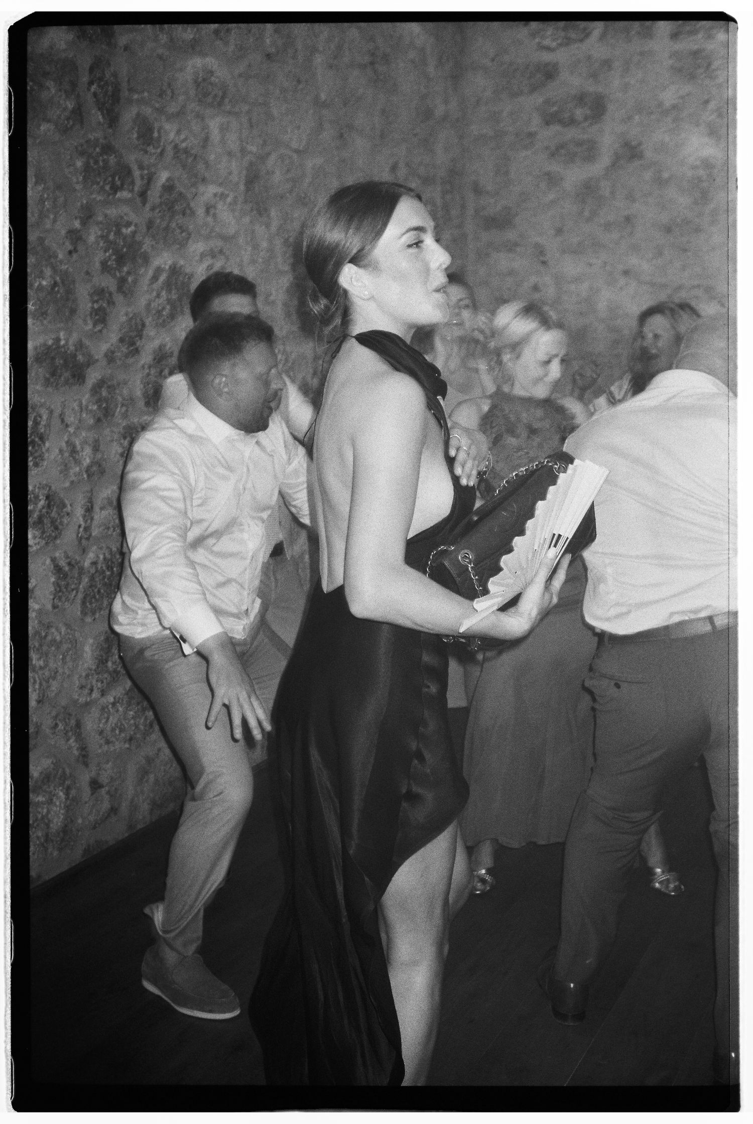 Black and white photos of guests dancing and celebrating at a lively party.