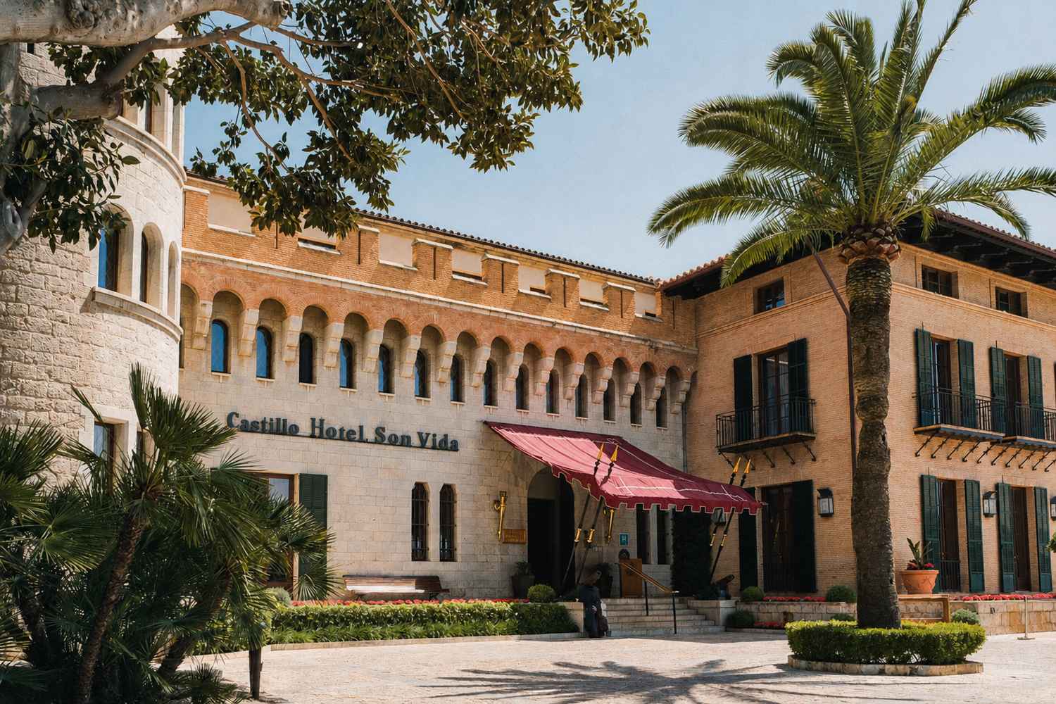 Castillo Hotel Son Vida exterior with palm trees, arched windows, and red awning in Mallorca, Spain.