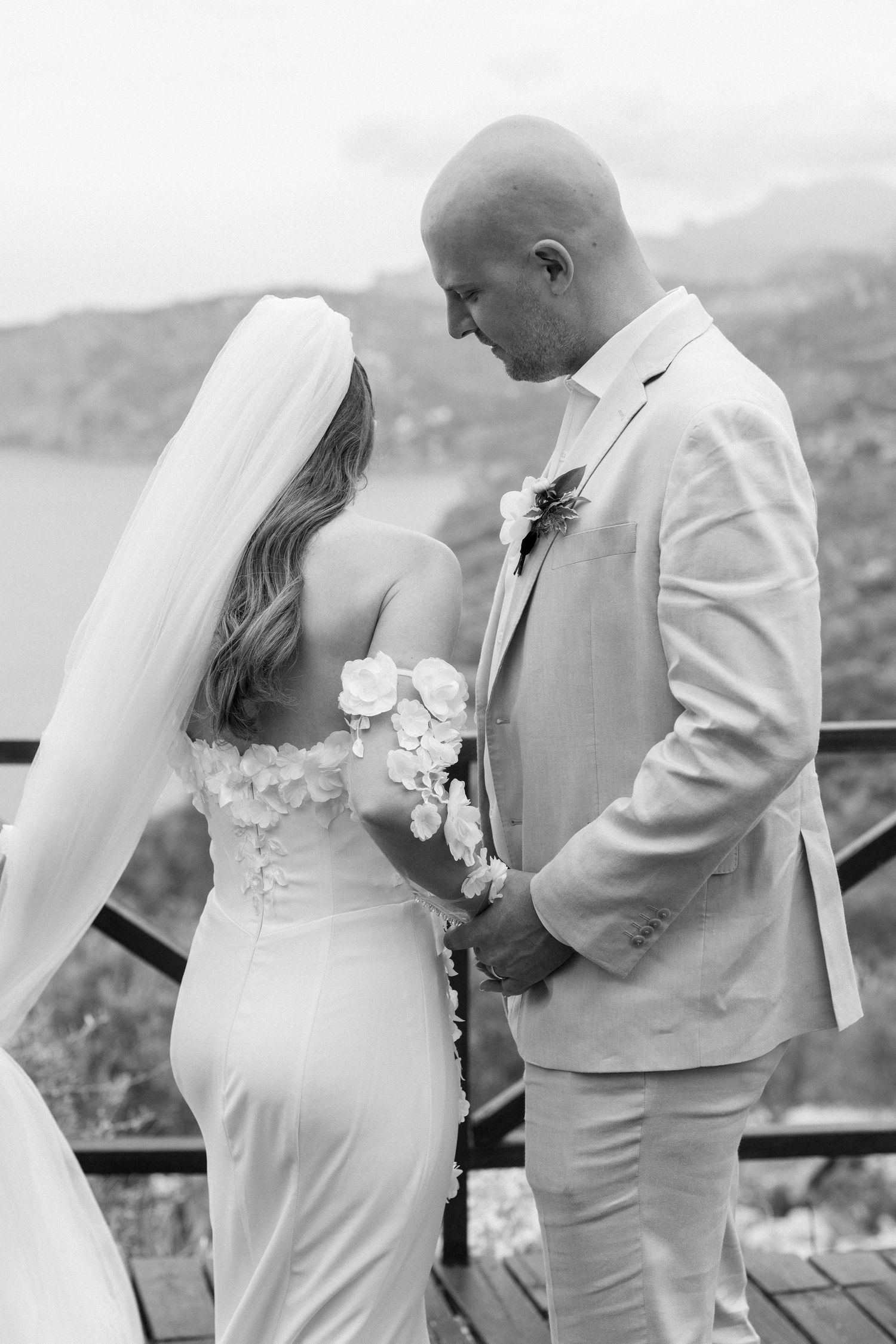 Black and white wedding photography series showing tender moments on an ocean-view terrace.