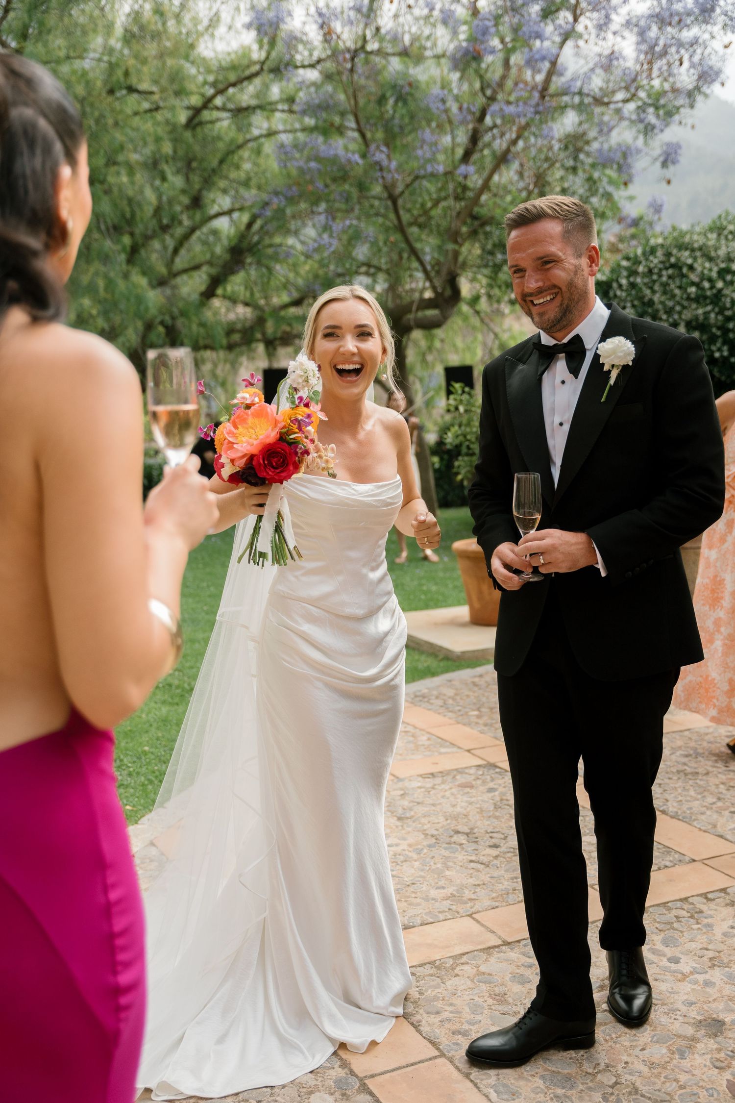 Candid moments of a bride and groom sharing laughs during their outdoor wedding reception.