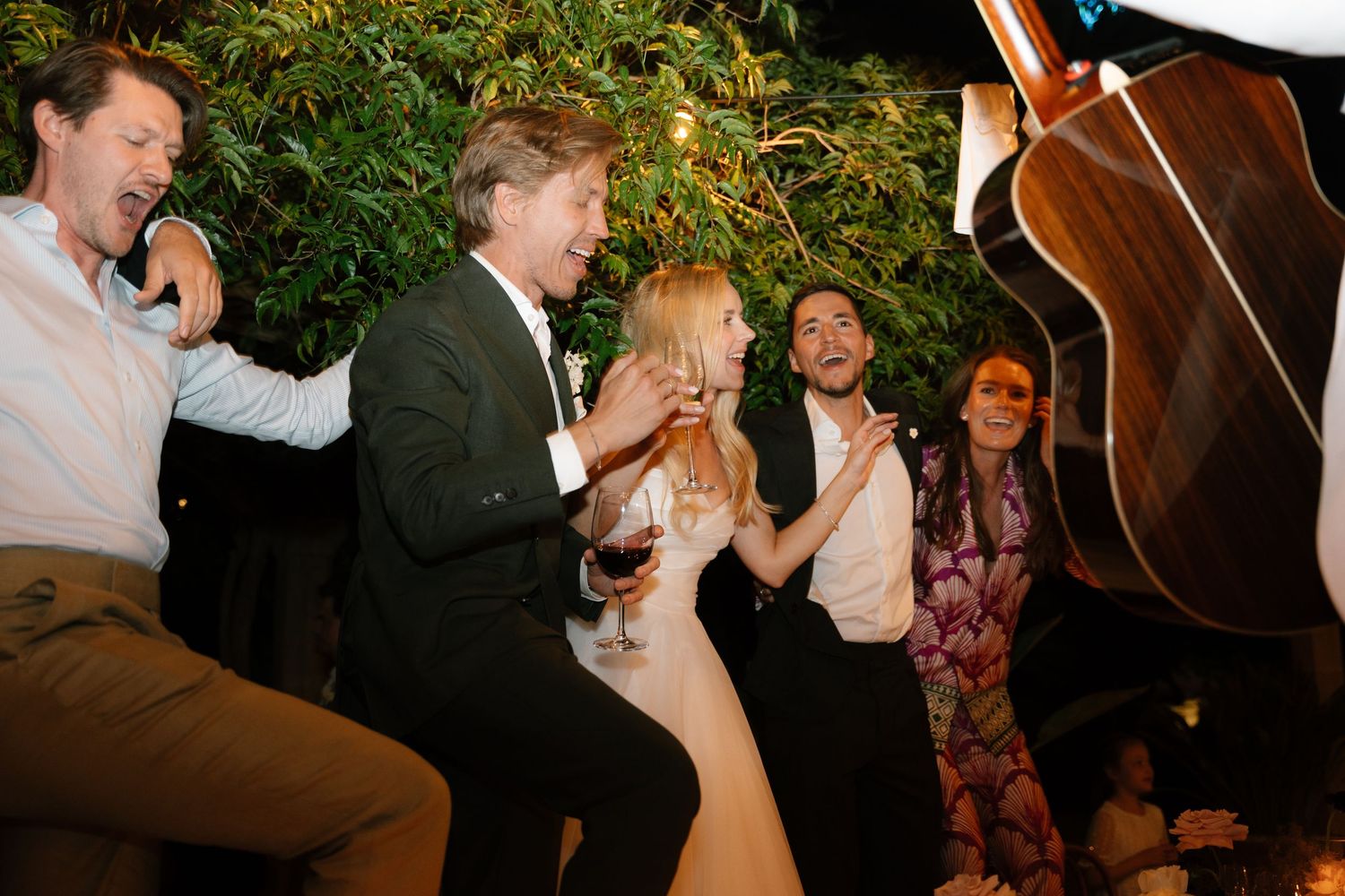 Wedding guests dance and celebrate at a lively reception party in black and white photography.