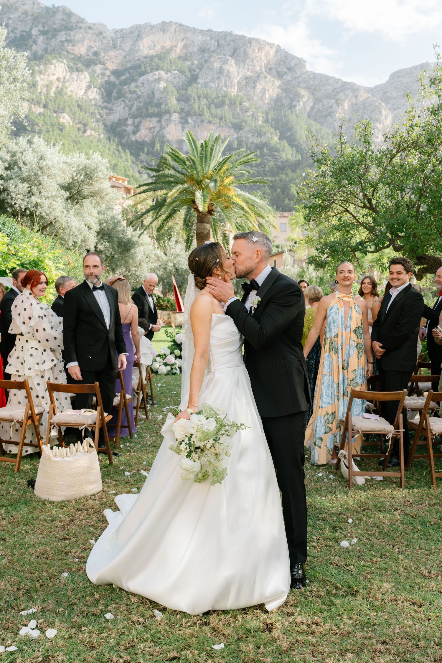 Guests celebrate as newlyweds walk down the aisle at their mountain garden wedding.