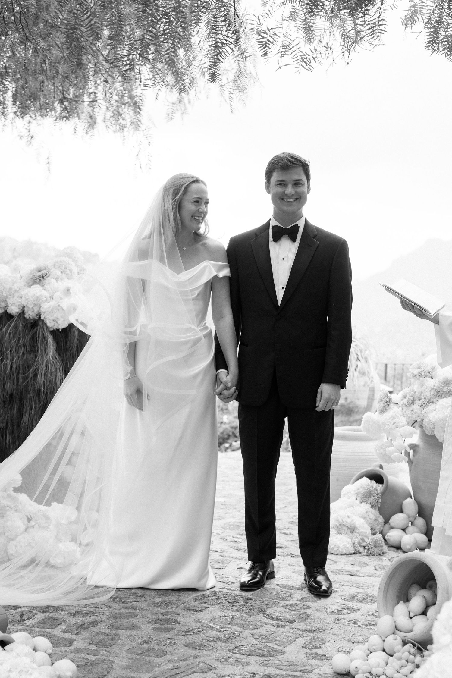A series of artistic black and white wedding photos capture moments between a couple on a sandy beach.