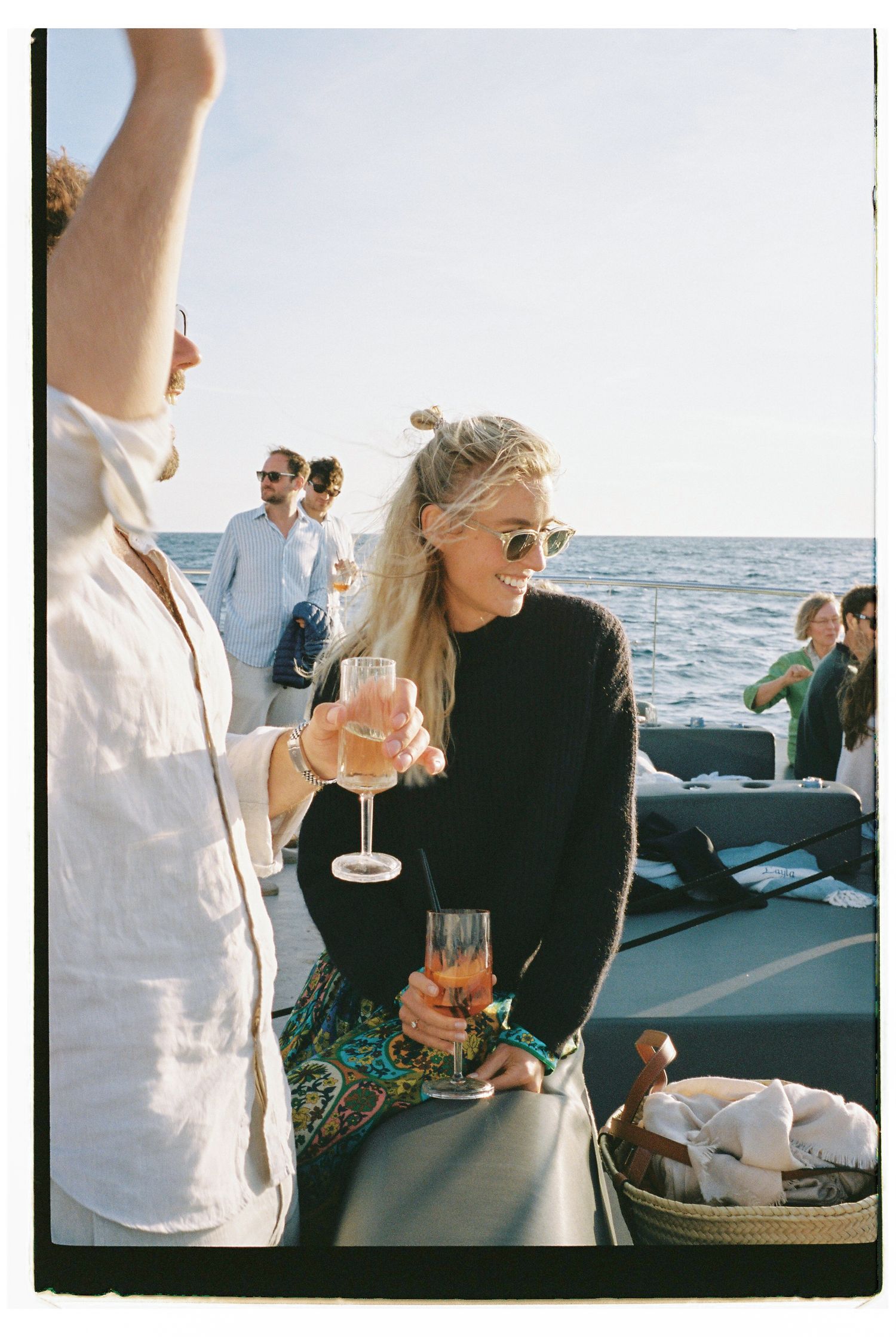 People enjoying drinks and conversation on a yacht during an afternoon cruise.