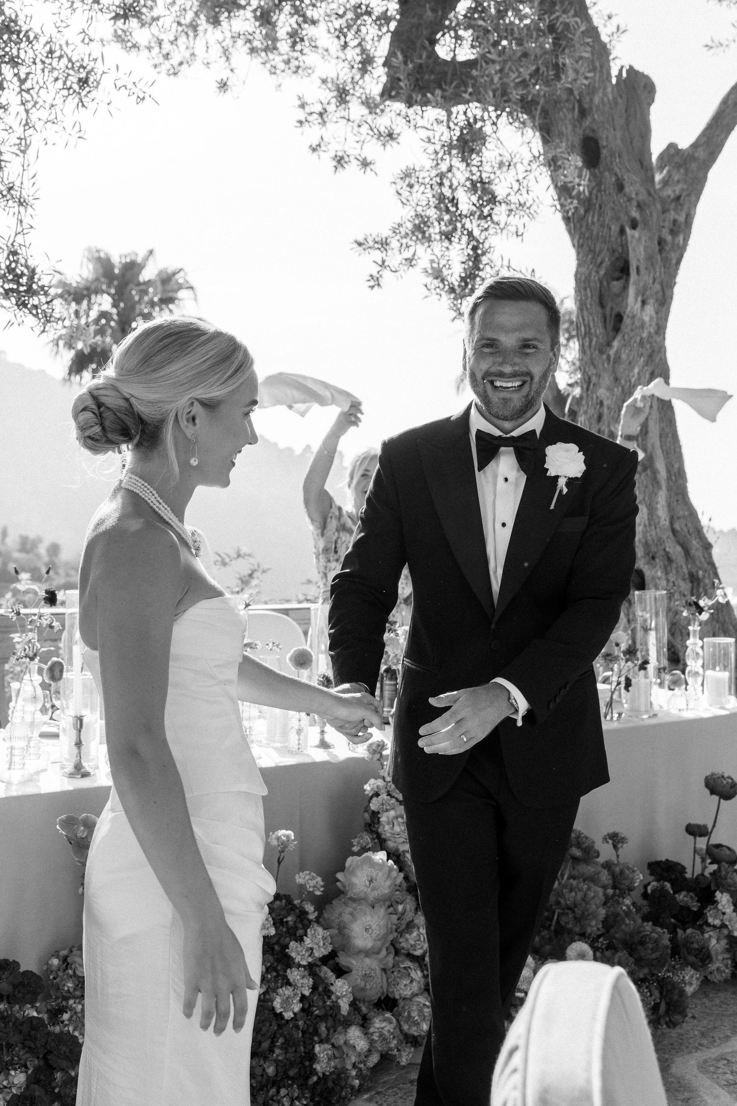 Joyful wedding moments captured under olive trees with mountain views.