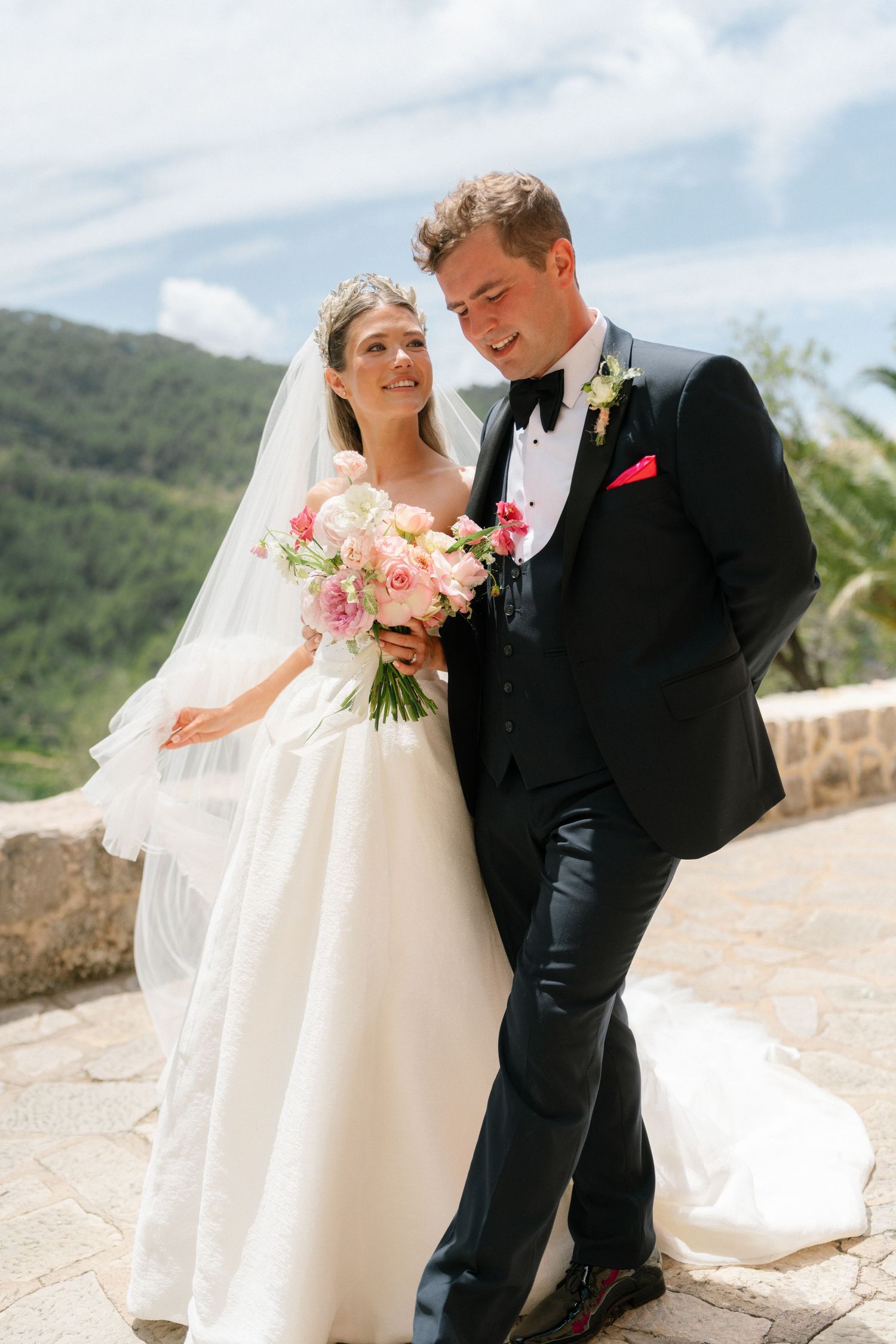 Romantic wedding portraits on stone terrace with mountain views in background.
