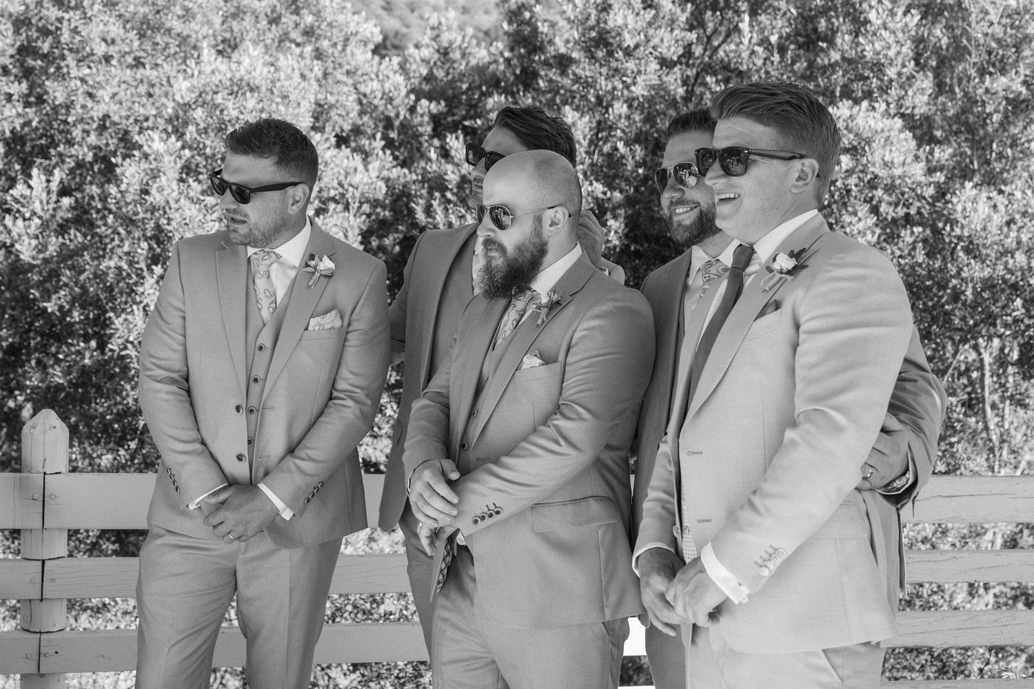 Wedding guests seated in formal attire at an outdoor ceremony.