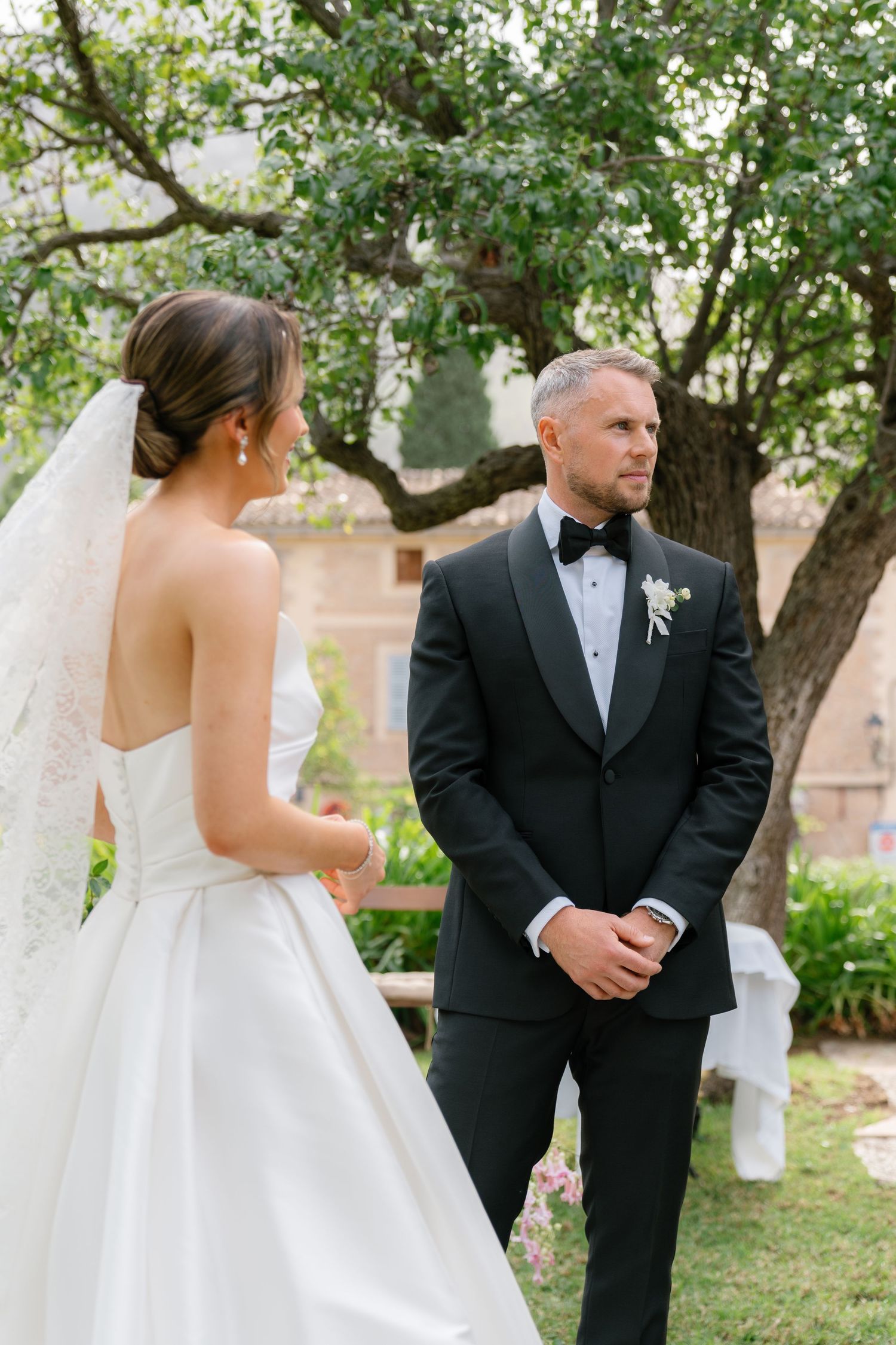 A couple shares a sweet first look moment in a garden setting on their wedding day.
