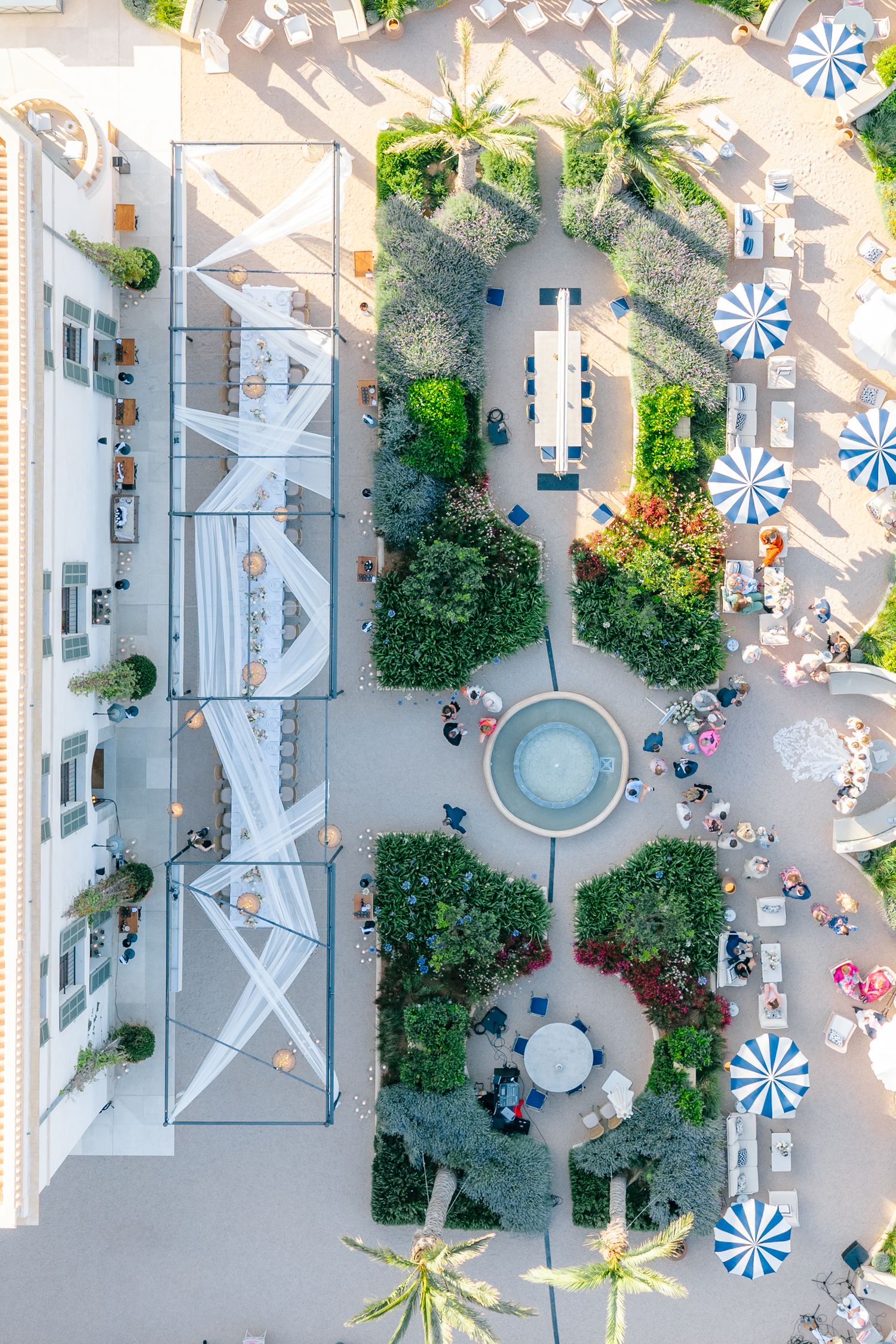 Aerial view of luxury resort layout with pools, umbrellas, and landscaped gardens.