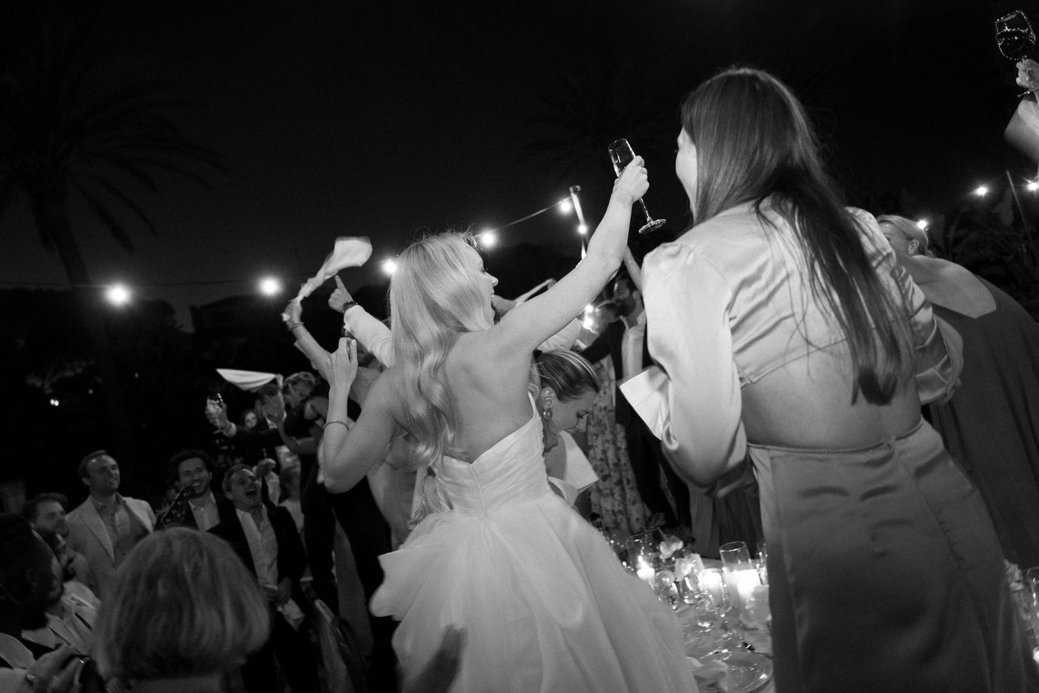 Energetic dancing and celebration captured in black and white at a wedding reception.
