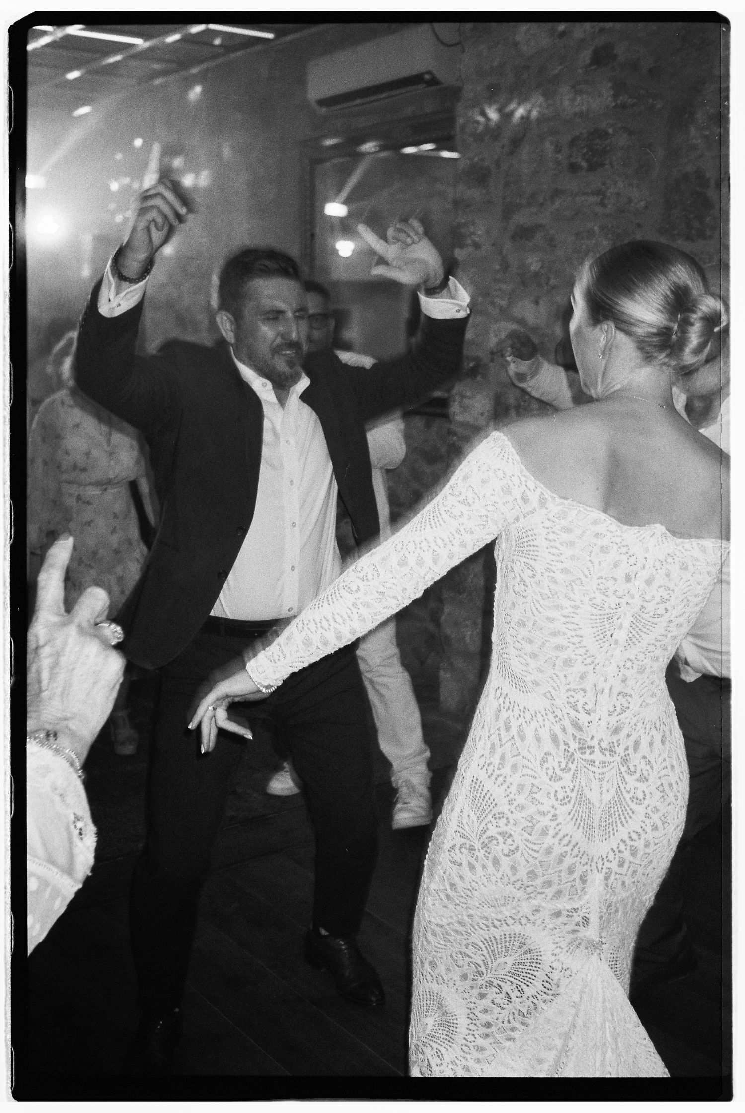 Wedding guests dancing and having fun on the dance floor in black and white.