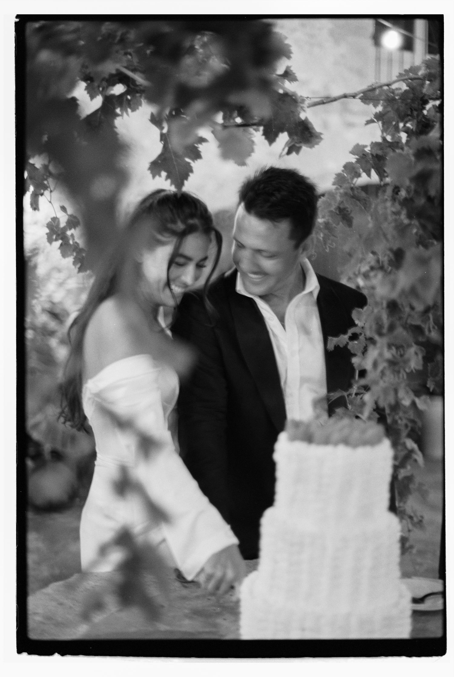 Black and white romantic wedding portraits under garden foliage at Sa Font Seca in Mallorca.