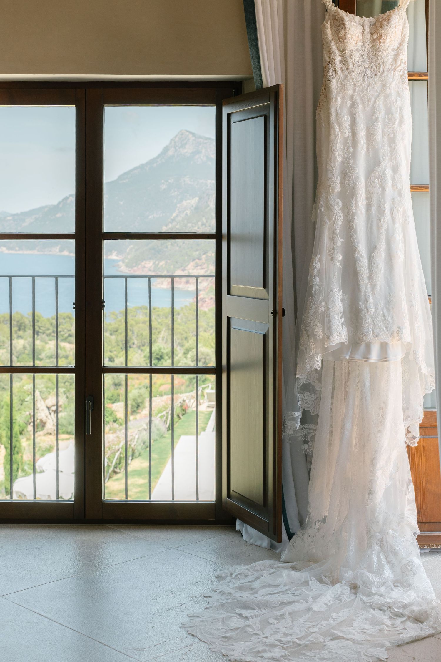 Wedding dresses displayed by windows with mountain views in a bridal suite.