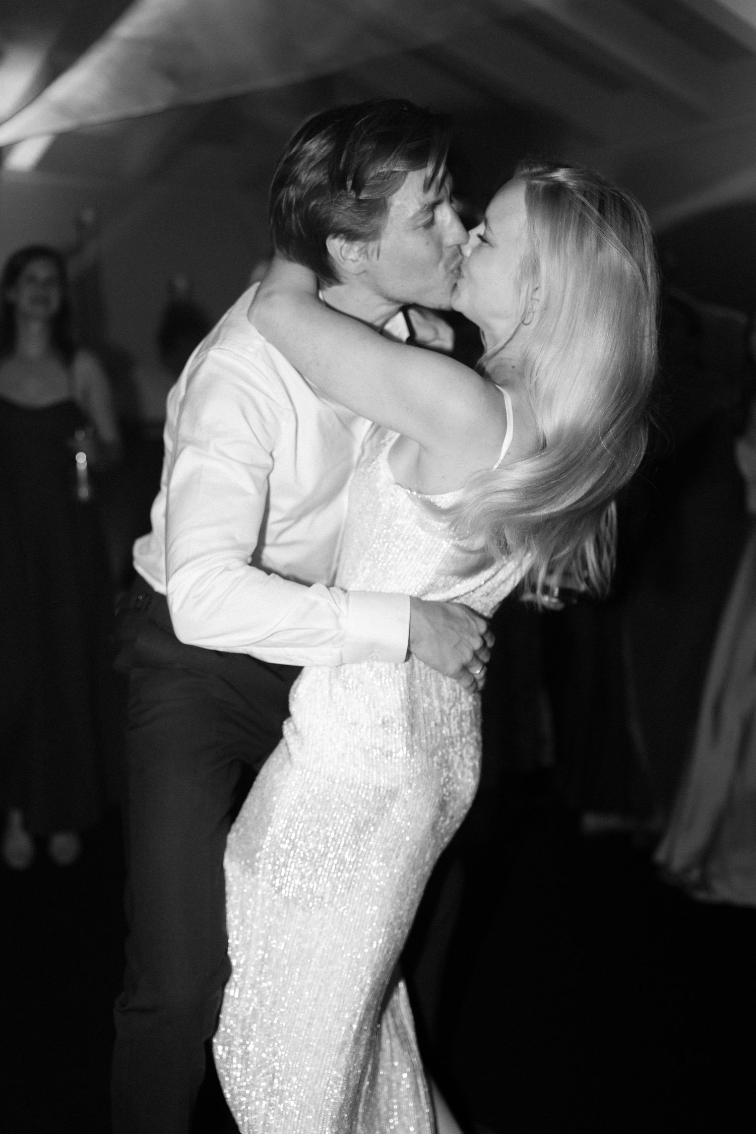 Romantic dance moment captured in dramatic black and white lighting.