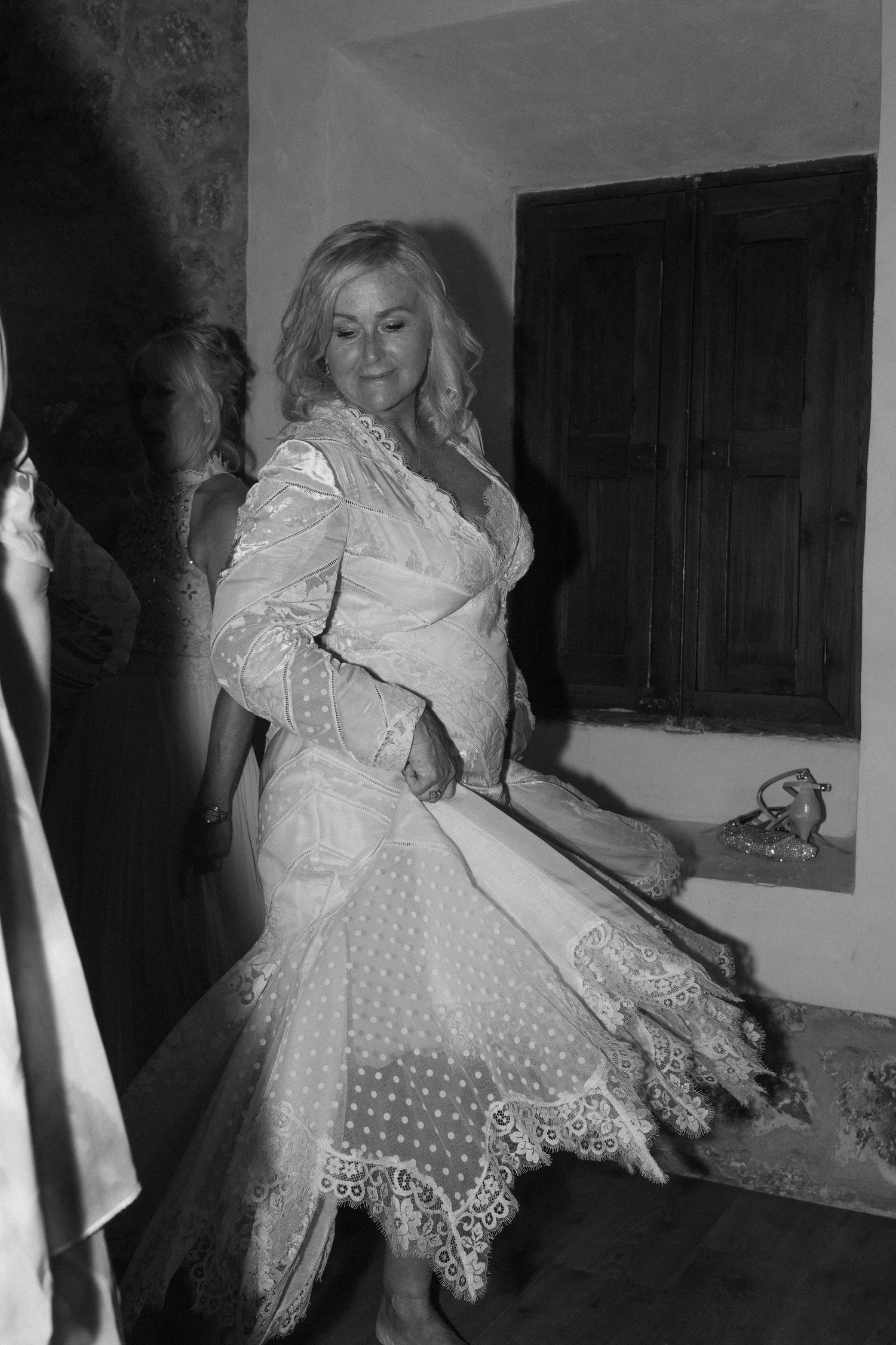 A person in a white lace dress twirling on a dance floor.