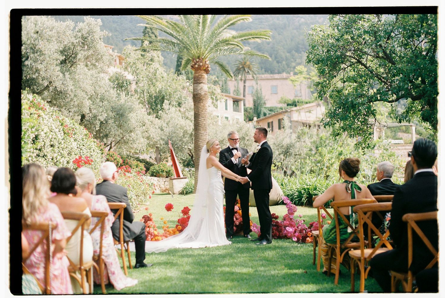 Outdoor wedding ceremony setup with wooden chairs and mountain views in the background.