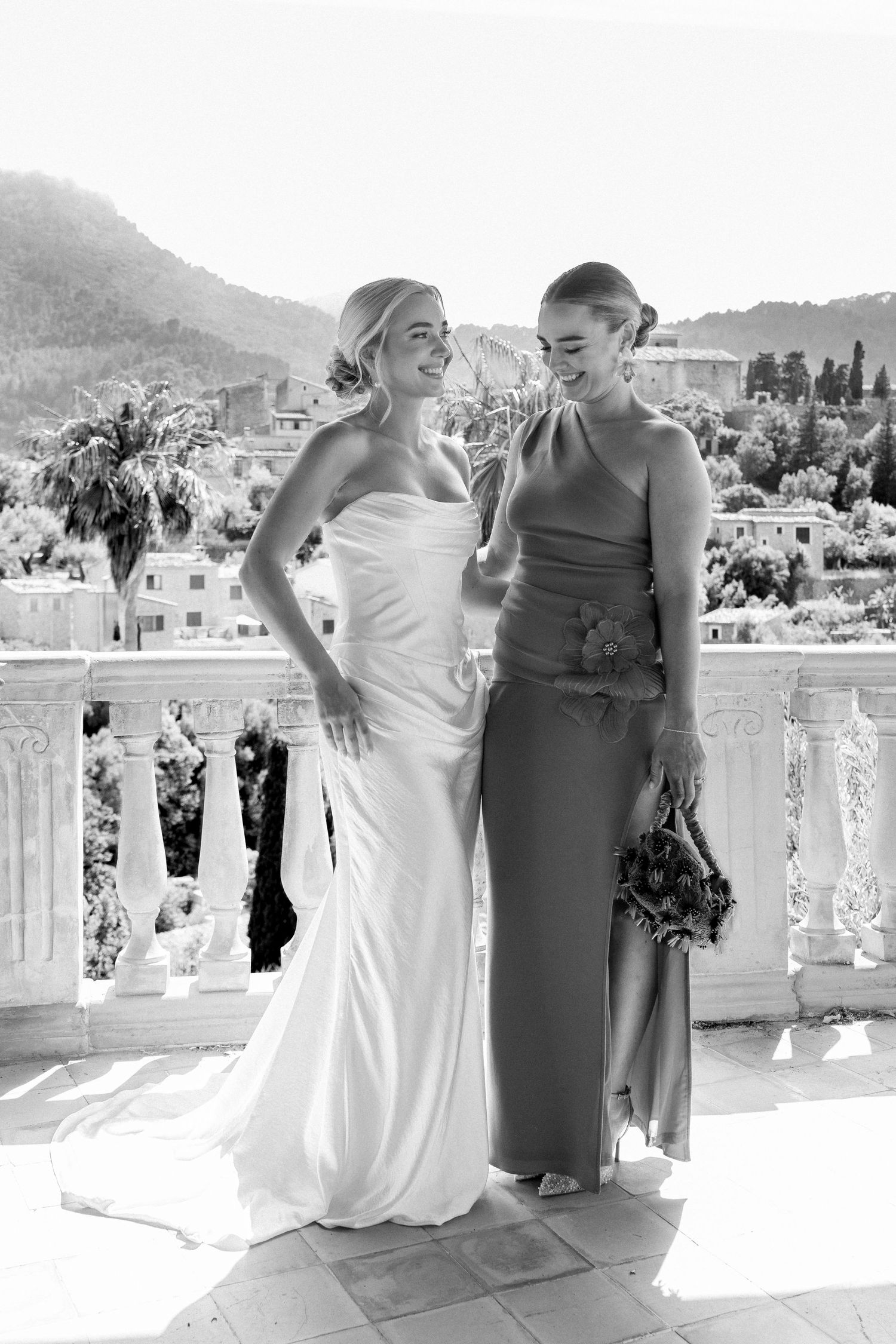 Wedding party poses on a white balcony with stunning mountain views in the background.