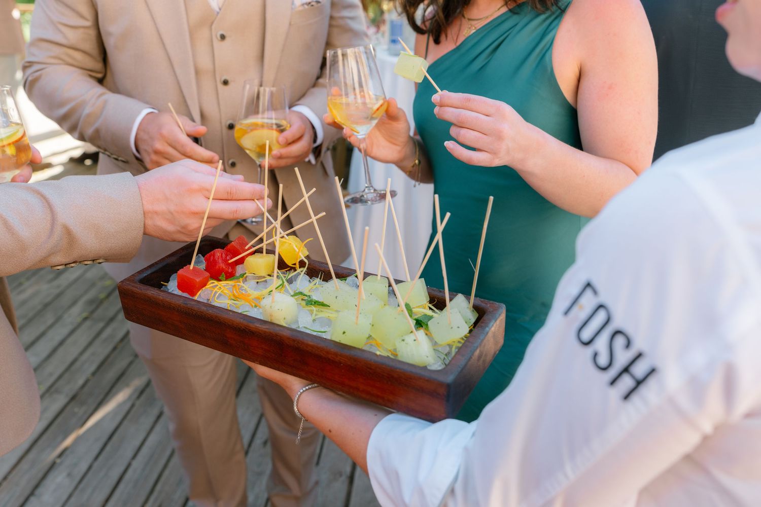 Wedding guests enjoying appetizers and drinks at an outdoor reception.