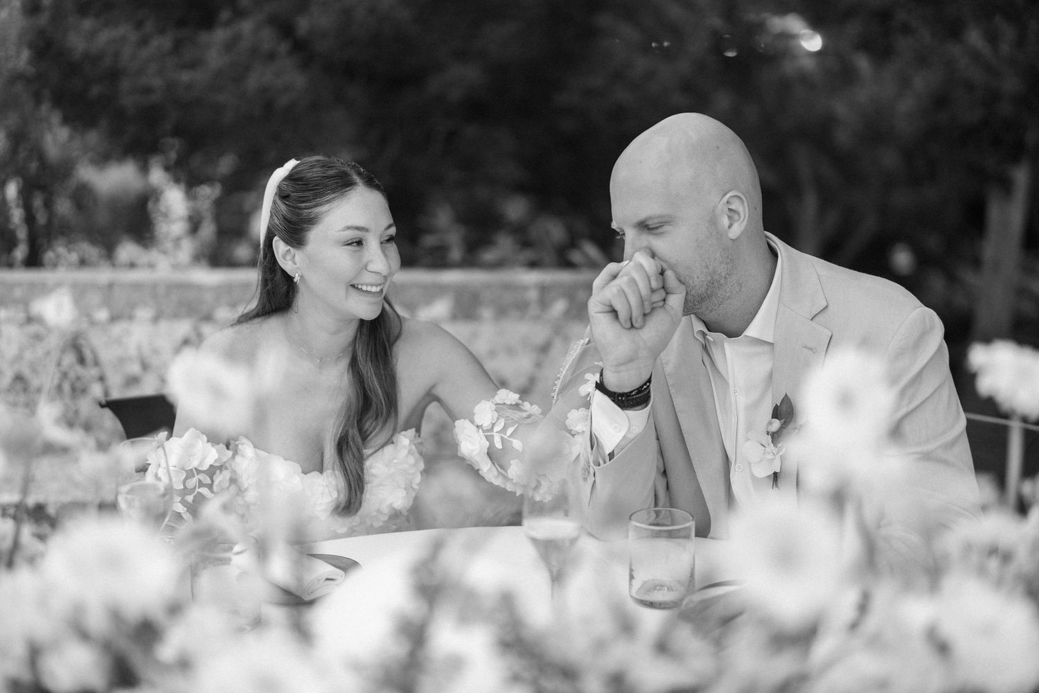 Black and white candid shots of a couple enjoying their wedding reception.